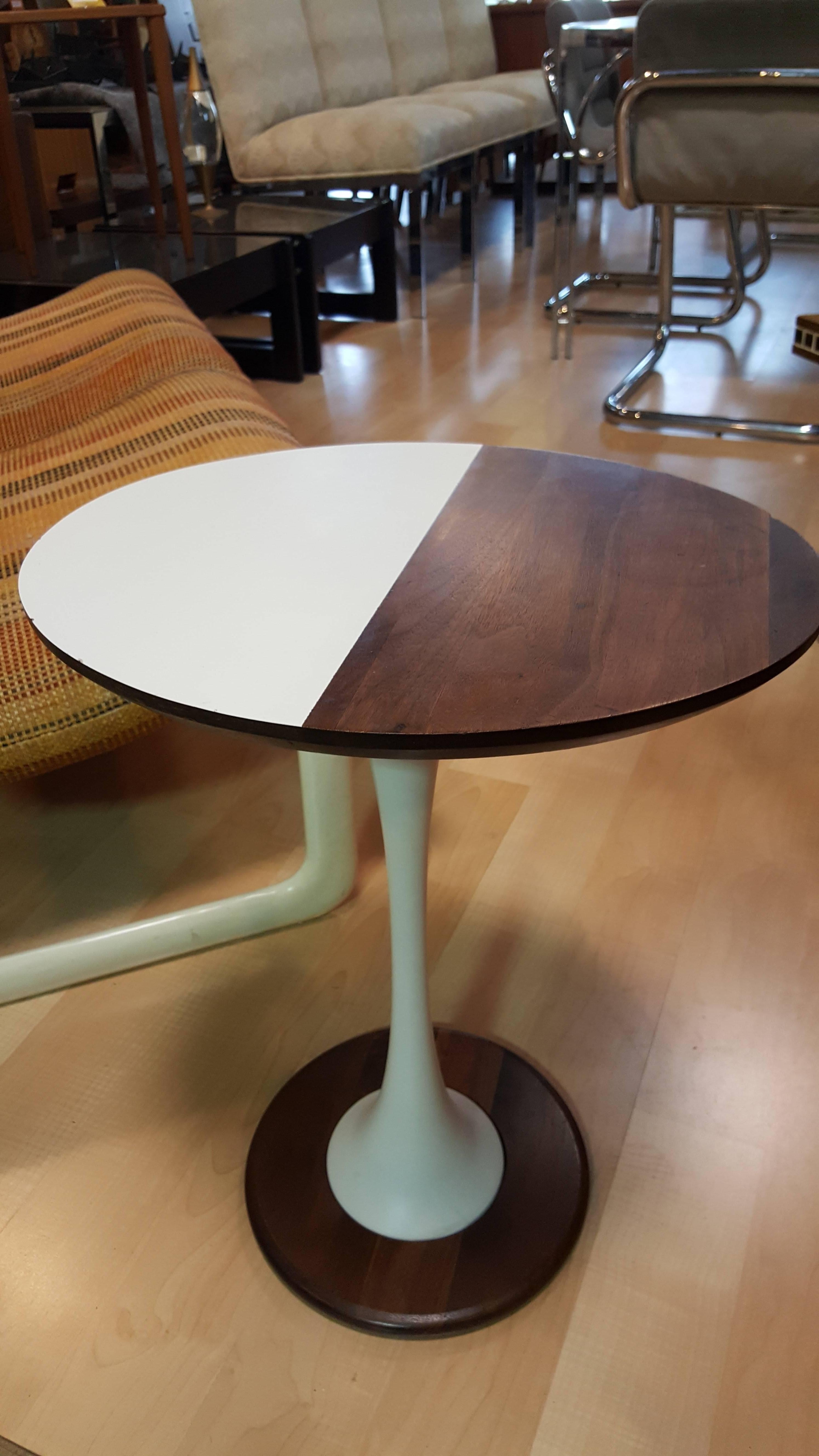 An unusual two-tone Eero Sarrinen style oval end table with a tulip base. Made with solid walnut, painted metal and white Formica.