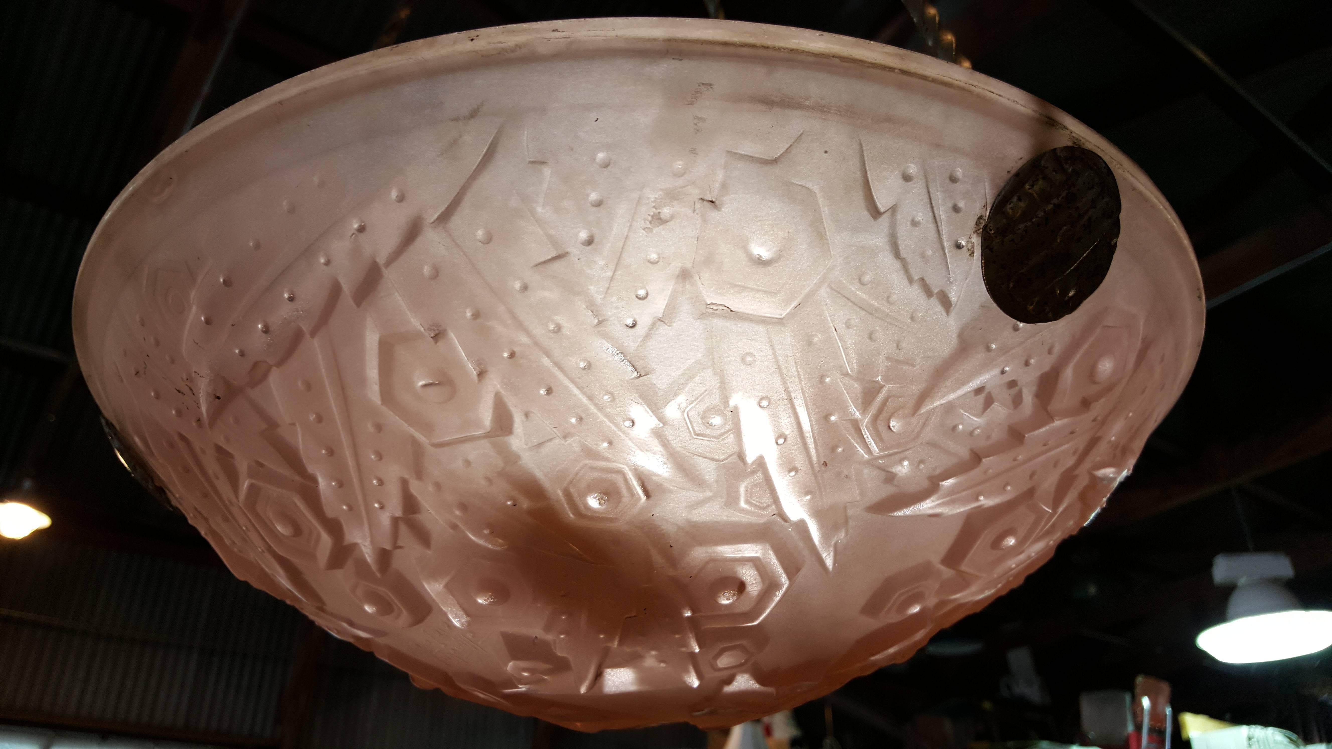 A signed Muller Freres Art Deco chandelier. Highly stylized leaf and flower pattern on a pink satin glass shade. Retaining all original metal mounts. Shade is signed.