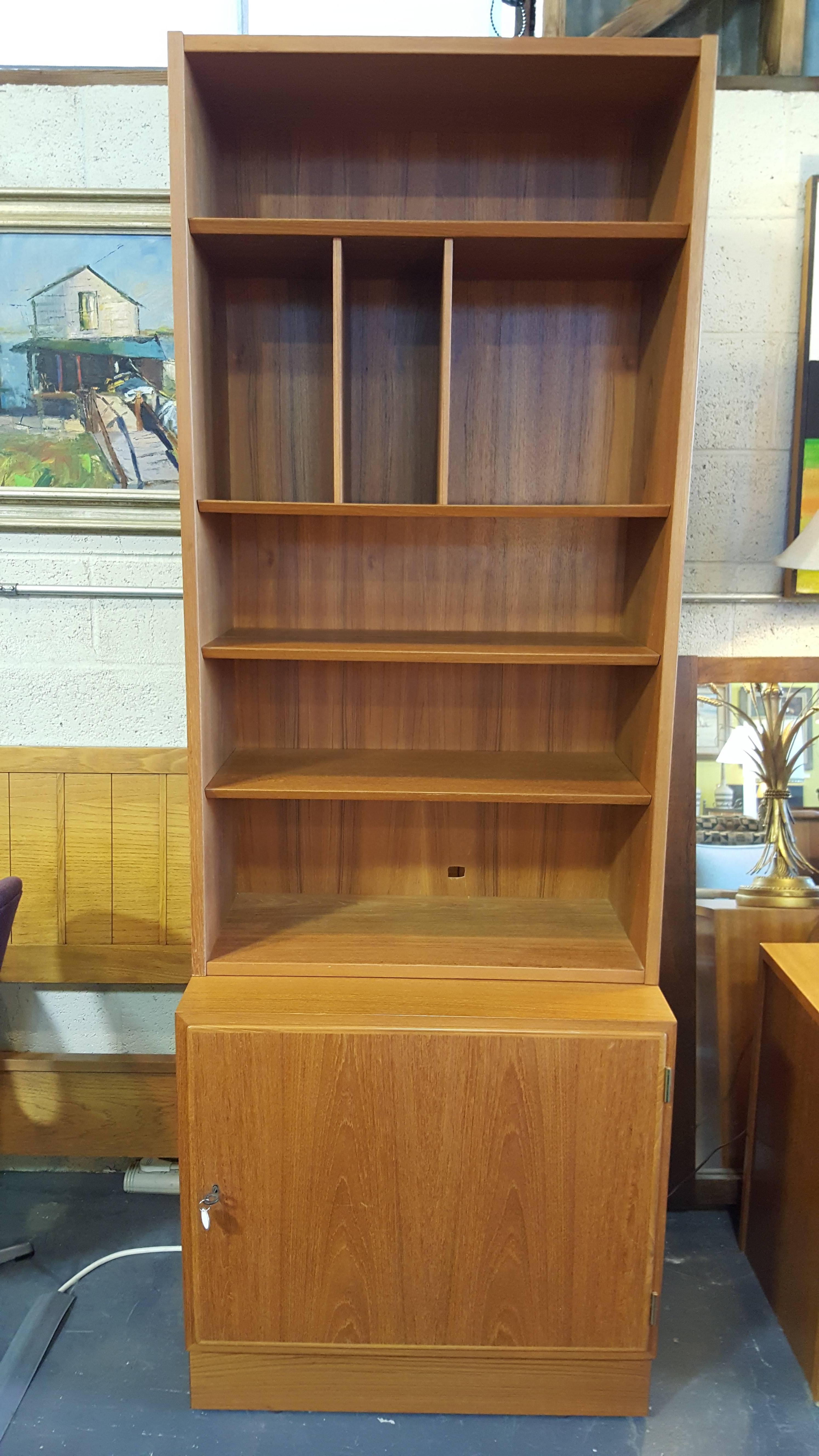 A two-piece teak storage cabinet or bookcase designed by Poul Hundevad, circa 1970. Ample storage with a small footprint. Top portion lifts off, therefore, lower cabinet may be used separately as top finish is in excellent condition. Lower cabinet