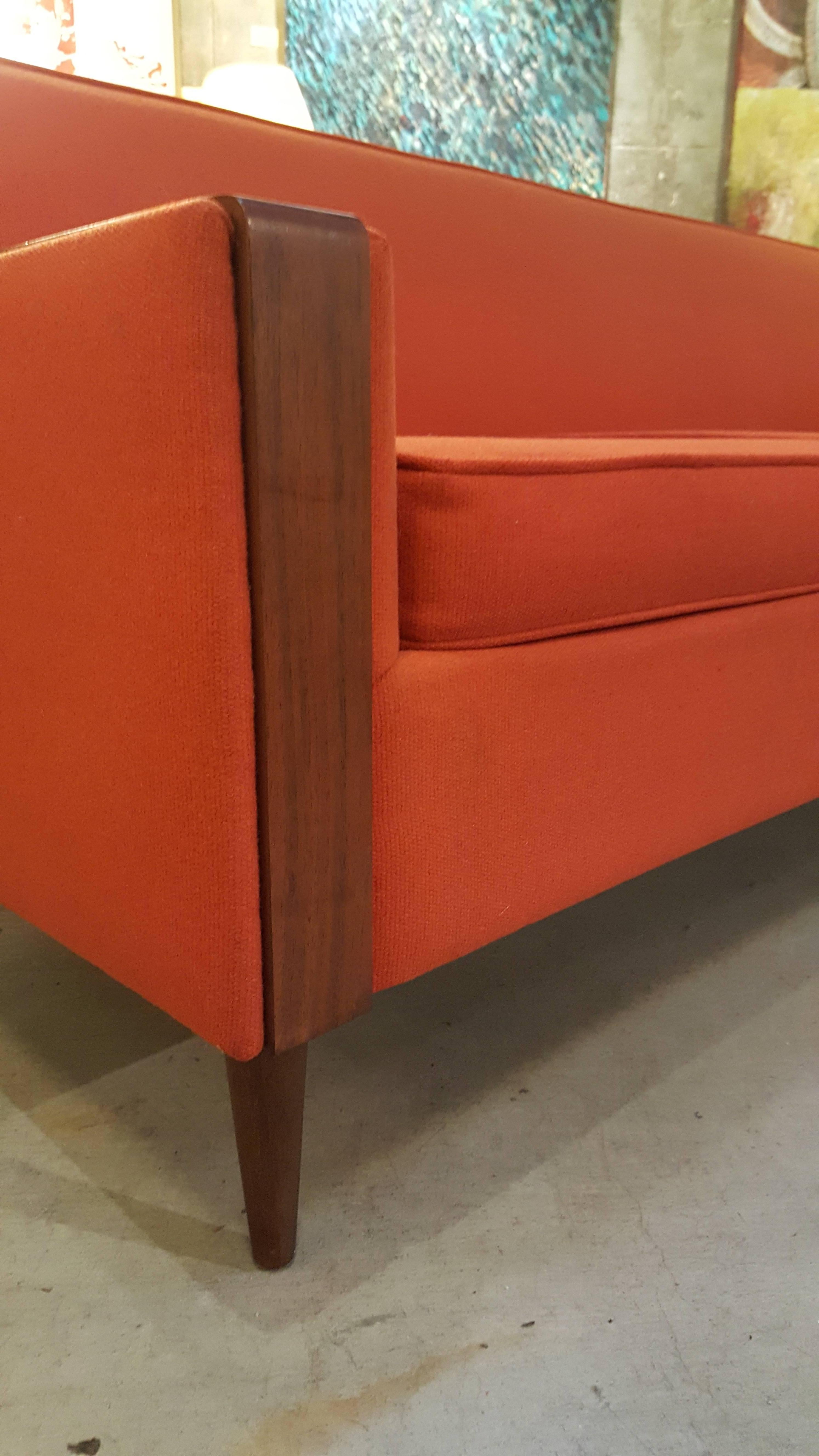 1960s Mid-Century Modern sofa with walnut detail to arms and Classic peg leg design. Good geometric lines in the style of Paul McCobb. Original upholstery in good condition with moderate wear. Re-upholstery recommended.
