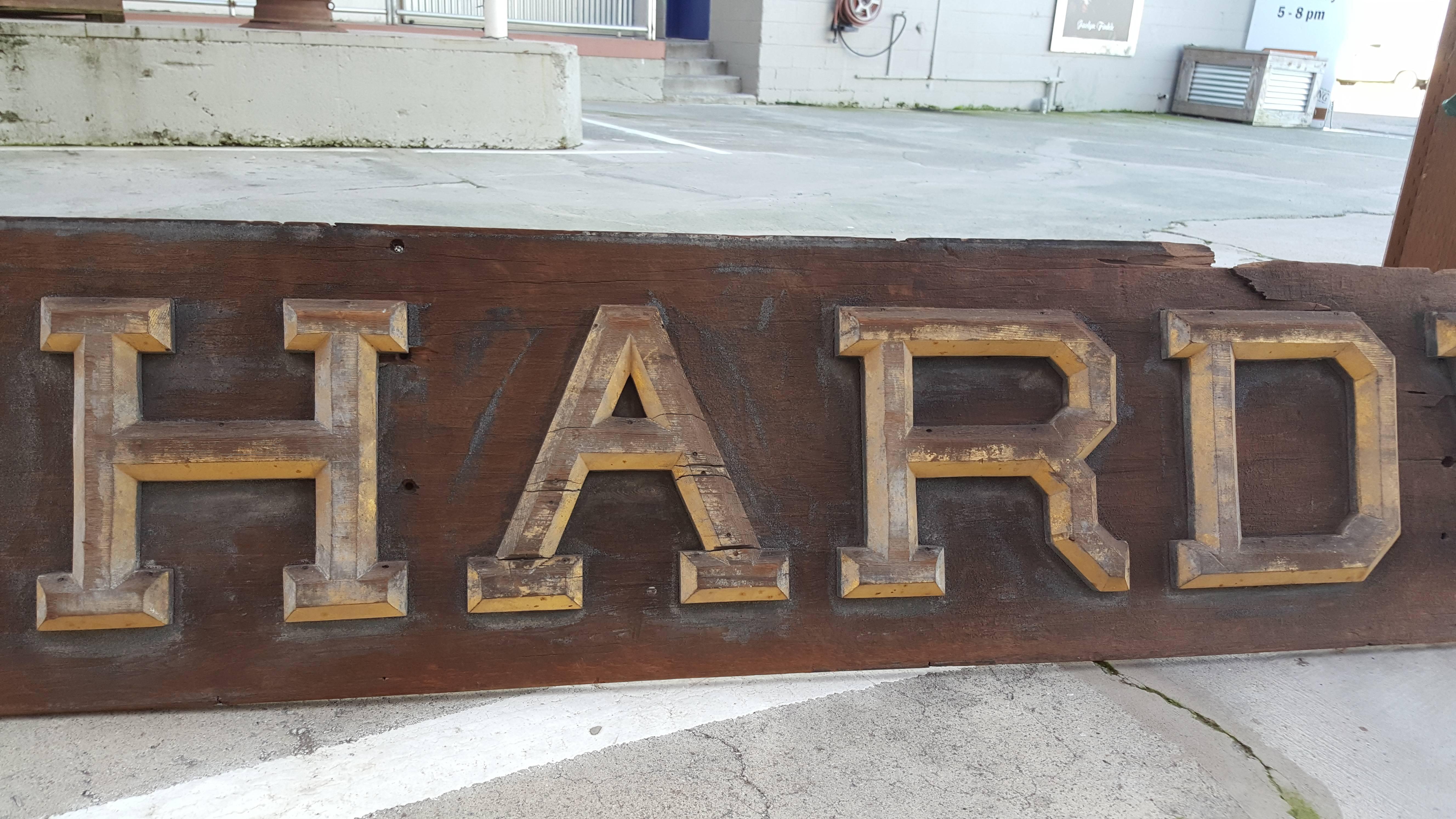 An antique commercial advertising sign made of a single piece of clear-heart redwood with applied two dimensional lettering. An impressive size with presence and character measuring over 10