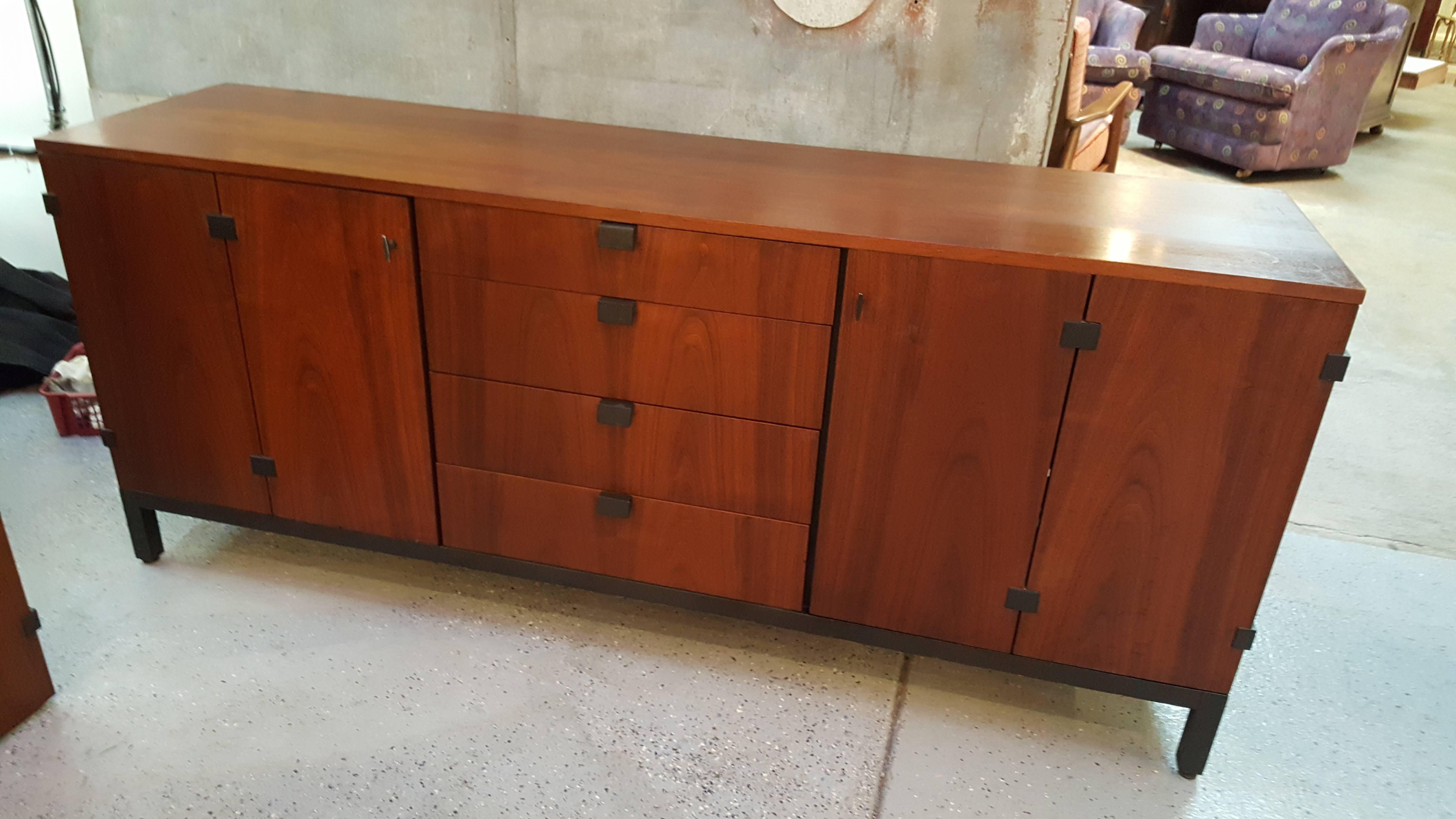 Impressive and unusual Mid-Century Modern walnut storage cabinet designed by Milo Baughman for Directional, circa 1960s. Ample storage with four sets of bi-fold doors, five slide out drawers and adjustable display shelving. Notice beautiful