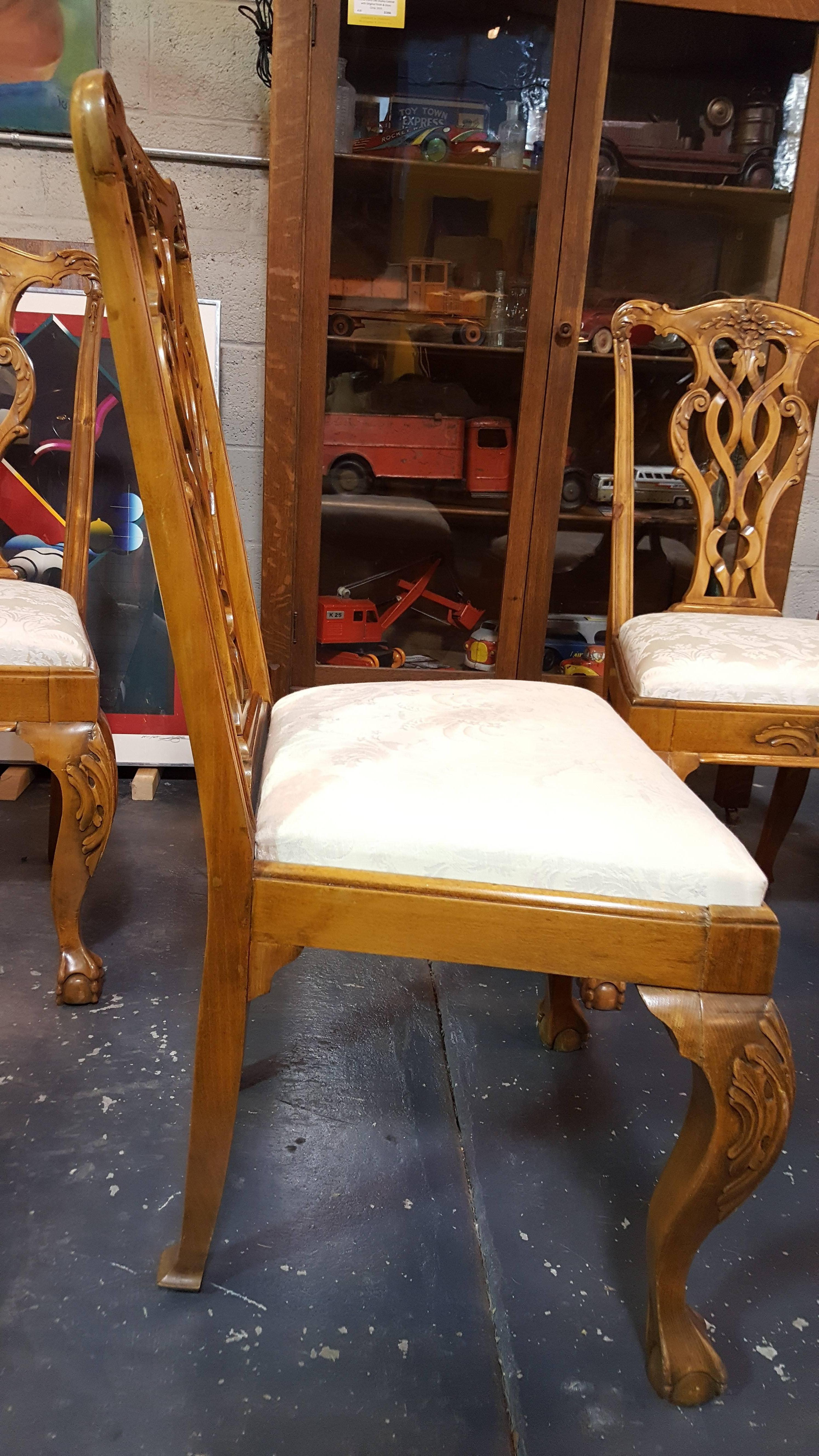 A set of four Chippendale style dining chairs. Hand-carved details with ball and claw foot, cabriolet leg, acanthus leaves and floral pattern. Older restoration, a solid, sturdy set of chairs. Upholstery in excellent condition.