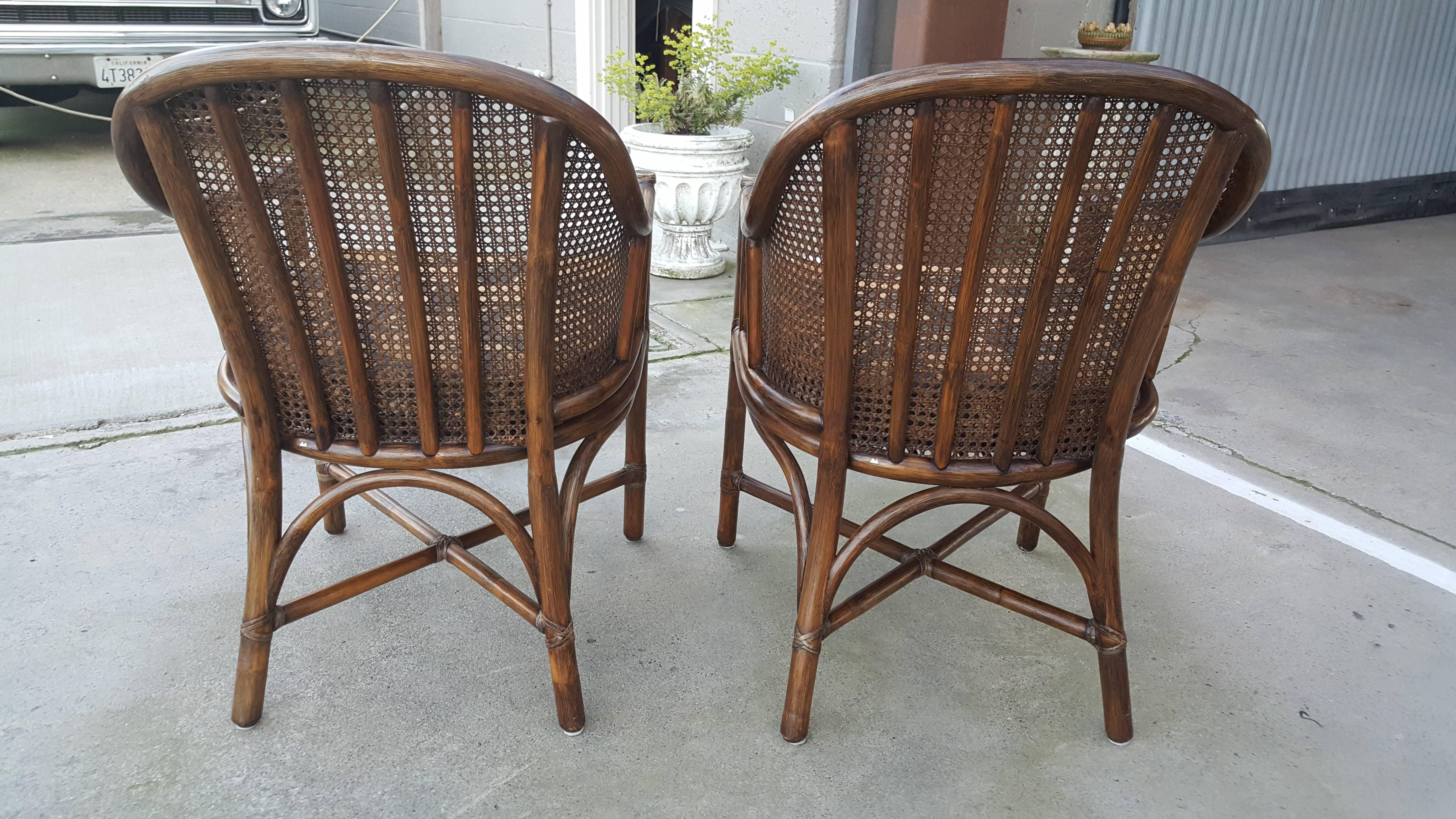 Nicely proportioned rattan and cane arm chairs by McGuire Furniture, San Francisco. Black and gold animal print fabric. Excellent vintage condition.
