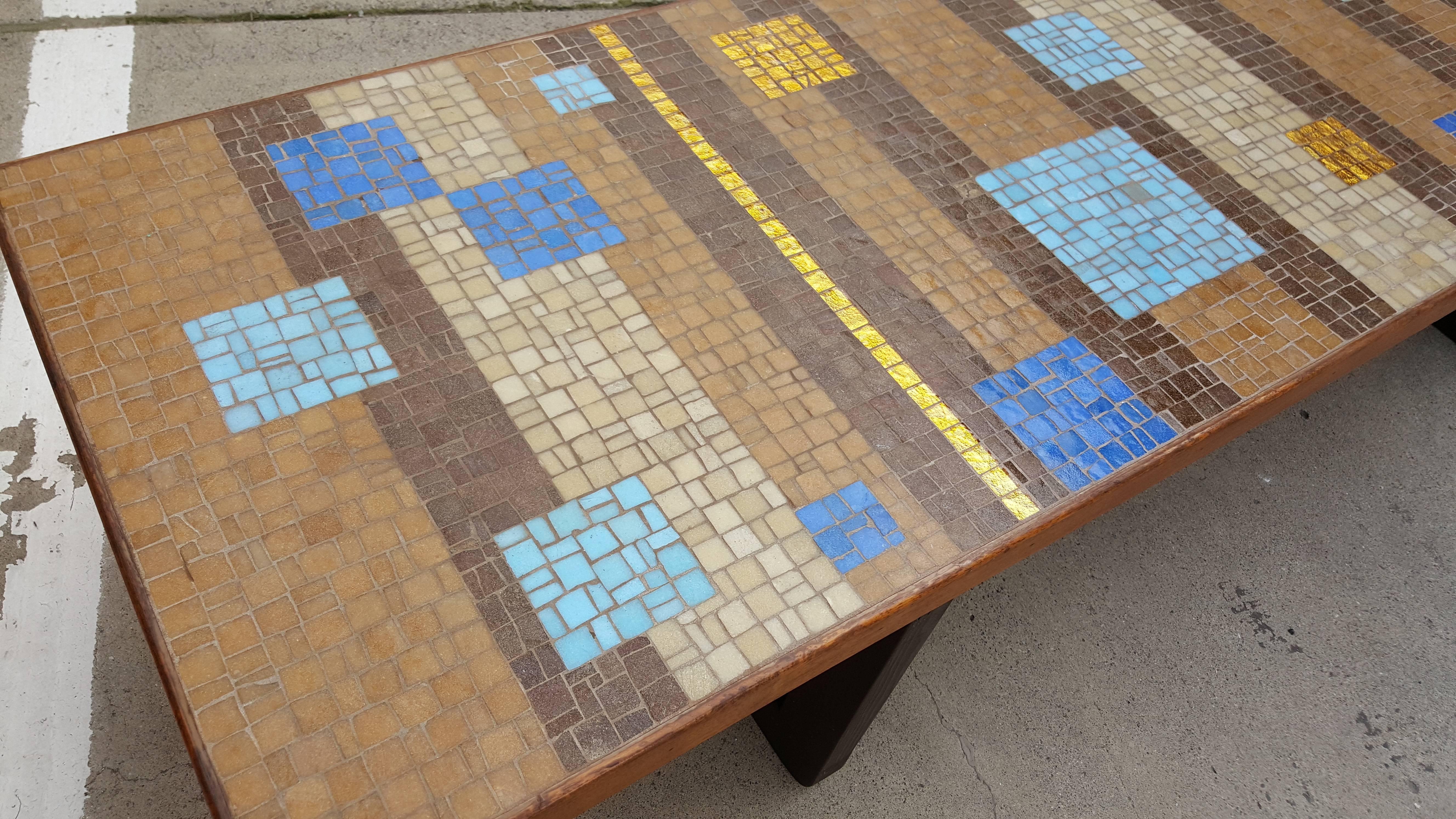Large-scale mosaic tile coffee table with geometric multi-color pattern. Gold foil tiles appear illuminated. Excellent choice of contrasting blues and turquoise against the organic background tiles. Solid, sturdy construction. Large surface as table