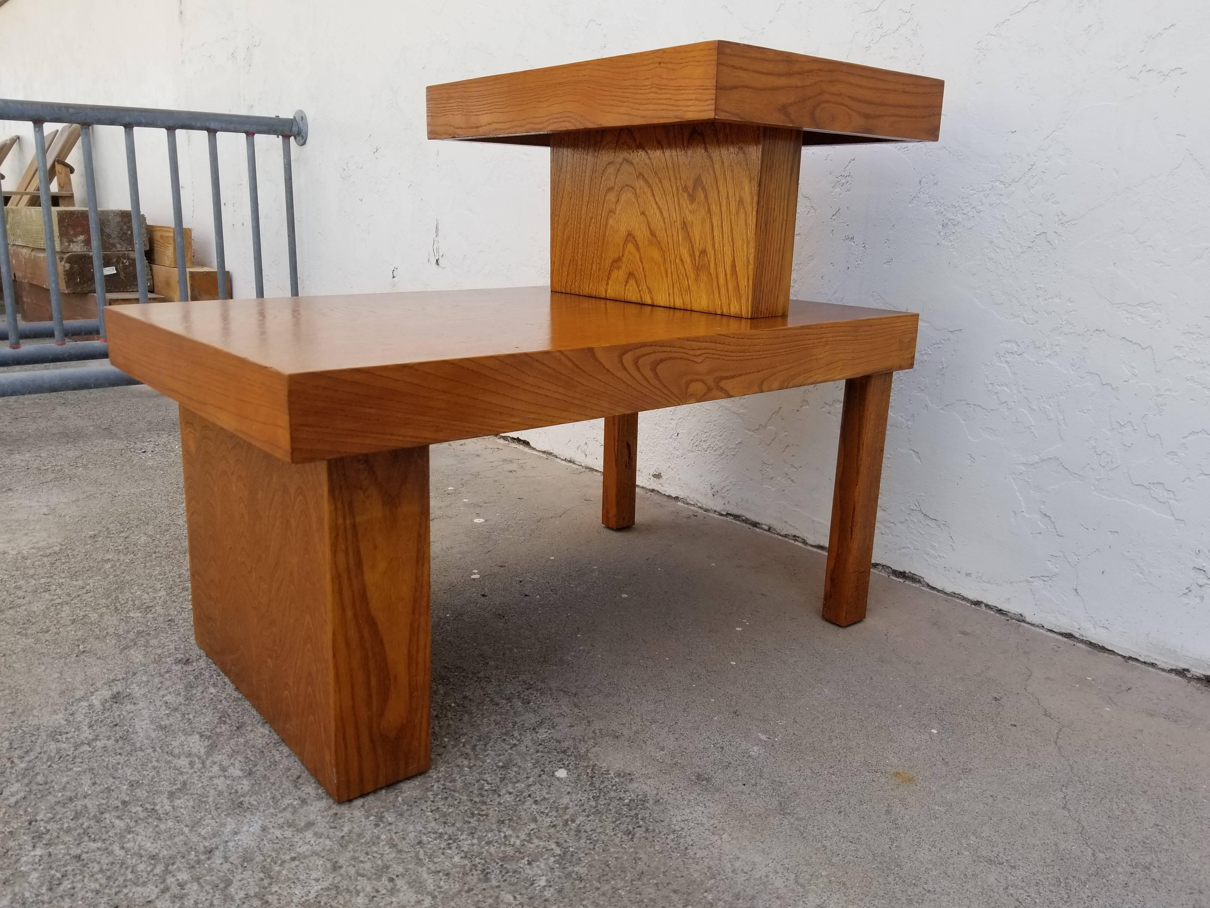 Bold architectural design and beautiful wood grain to this 1940's 50's industrial design end table. Notice the variation of dimensional proportions and off-sets to design. Lower table height measures 15.5