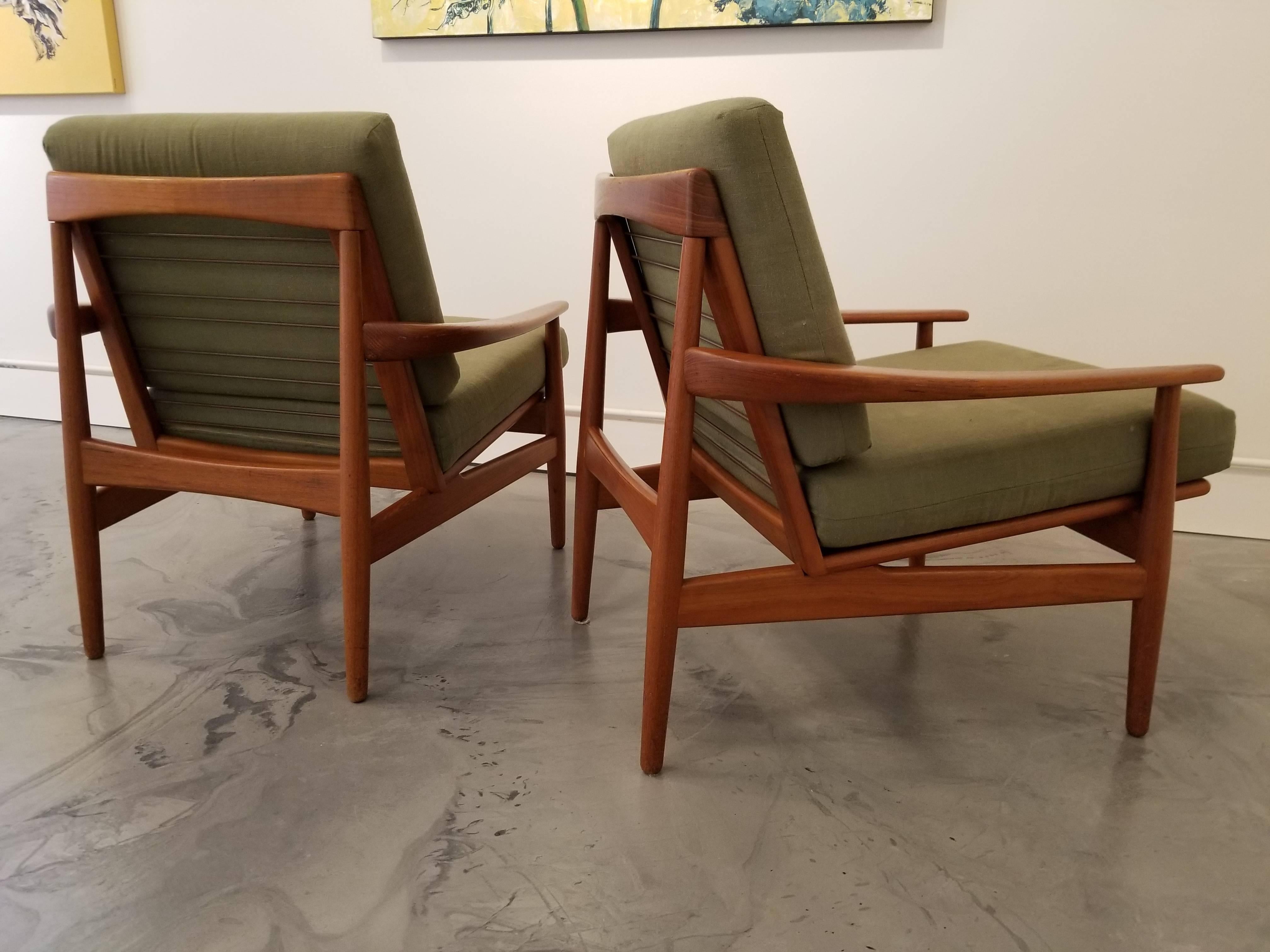 A fine pair of teak lounge chairs with exceptional craftsmanship to teak frames. Nice glow to original finish.