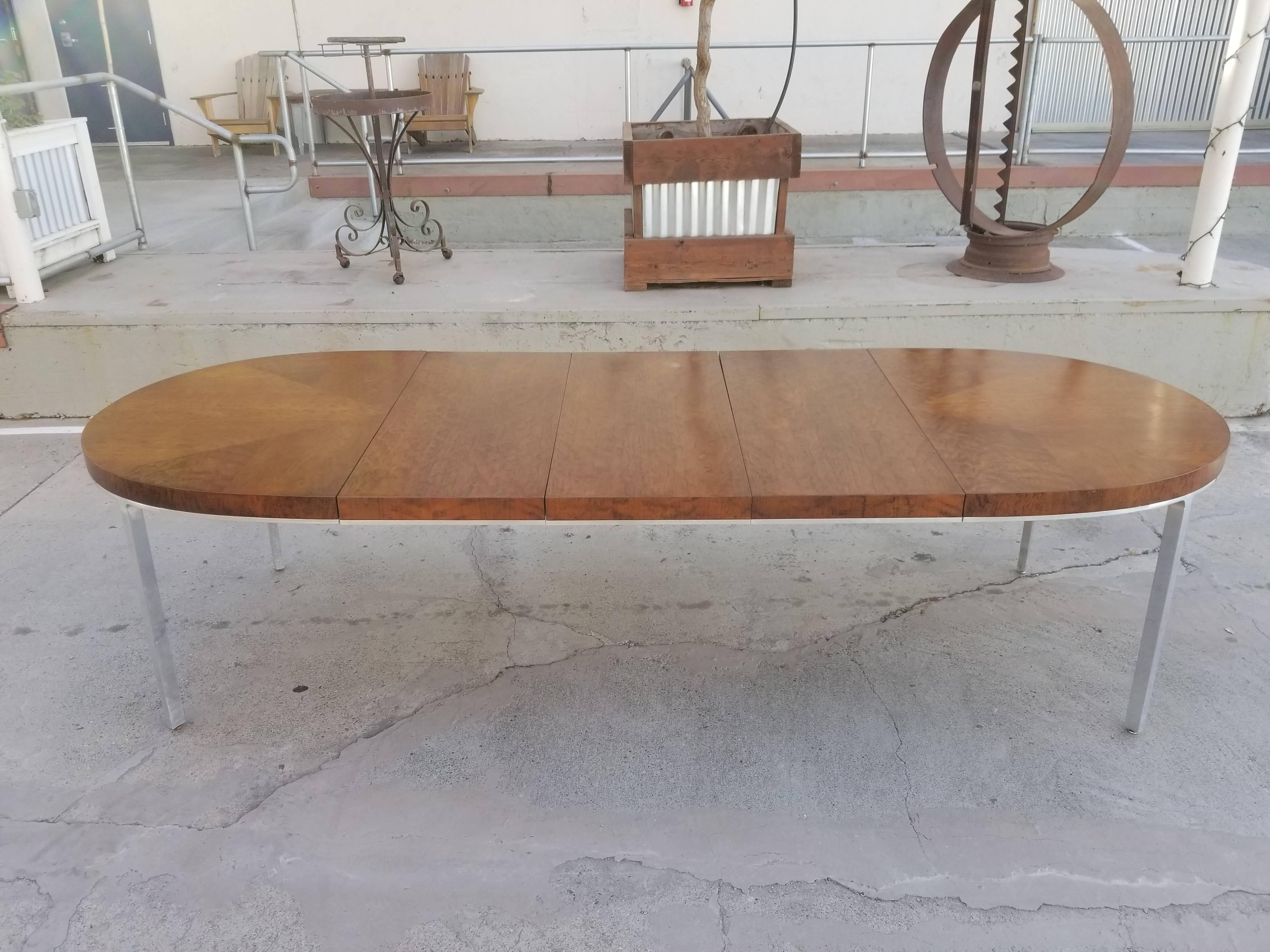 Expanding dining table that would also work well as a conference table. Polished aluminum apron and legs with a book-matched detail to veneer top. Quality construction and materials. Notice beautiful burl wood top surface. Original vintage condition
