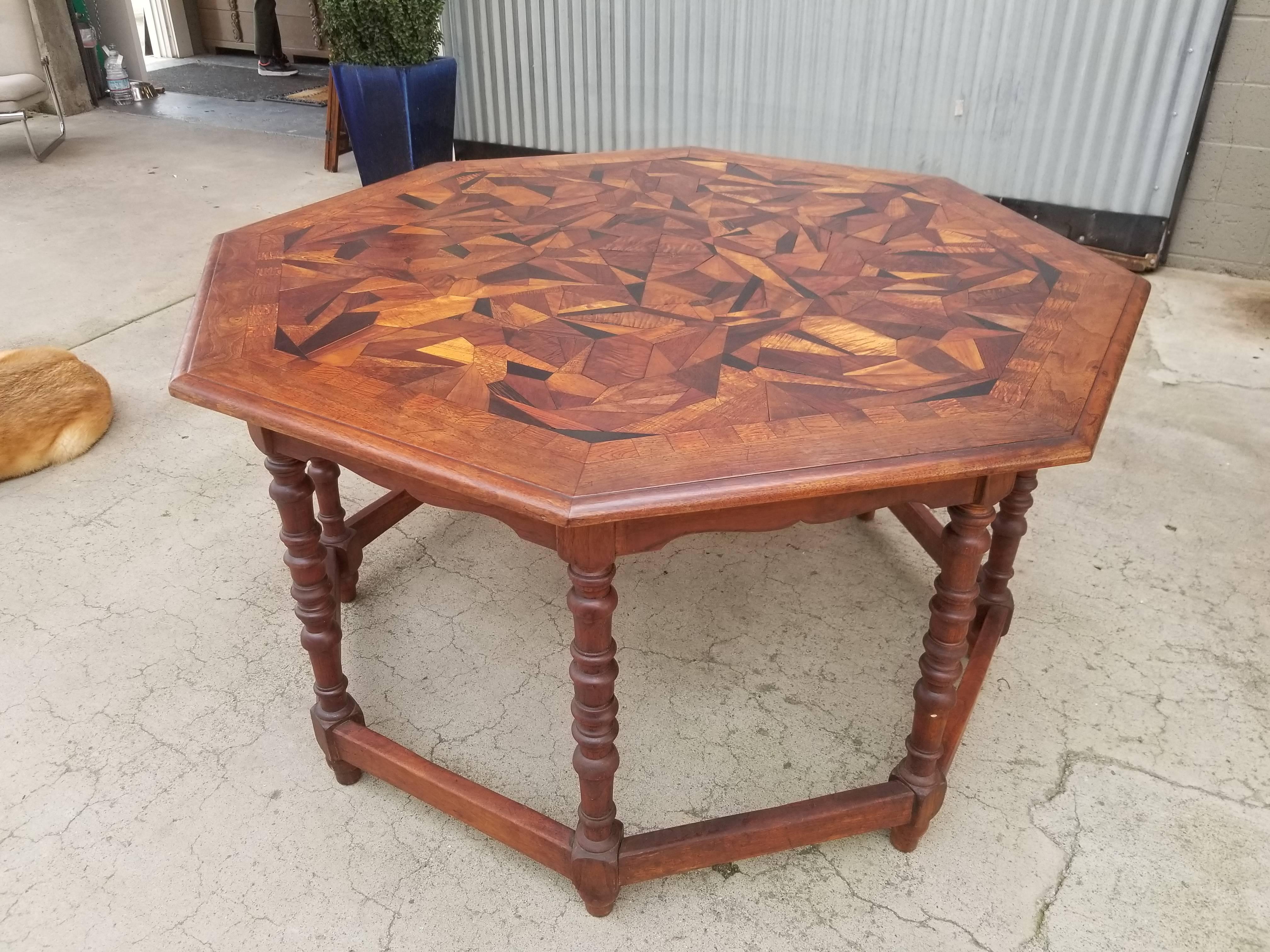 Unique, large-scale octagonal centre or entry table with fantastic geometric specimen wood inlaid top on a solid walnut base. Beautiful, warm glow to patina throughout entire table. Appears to be a one-of-a-kind Folk Art creation. Dramatic visual as