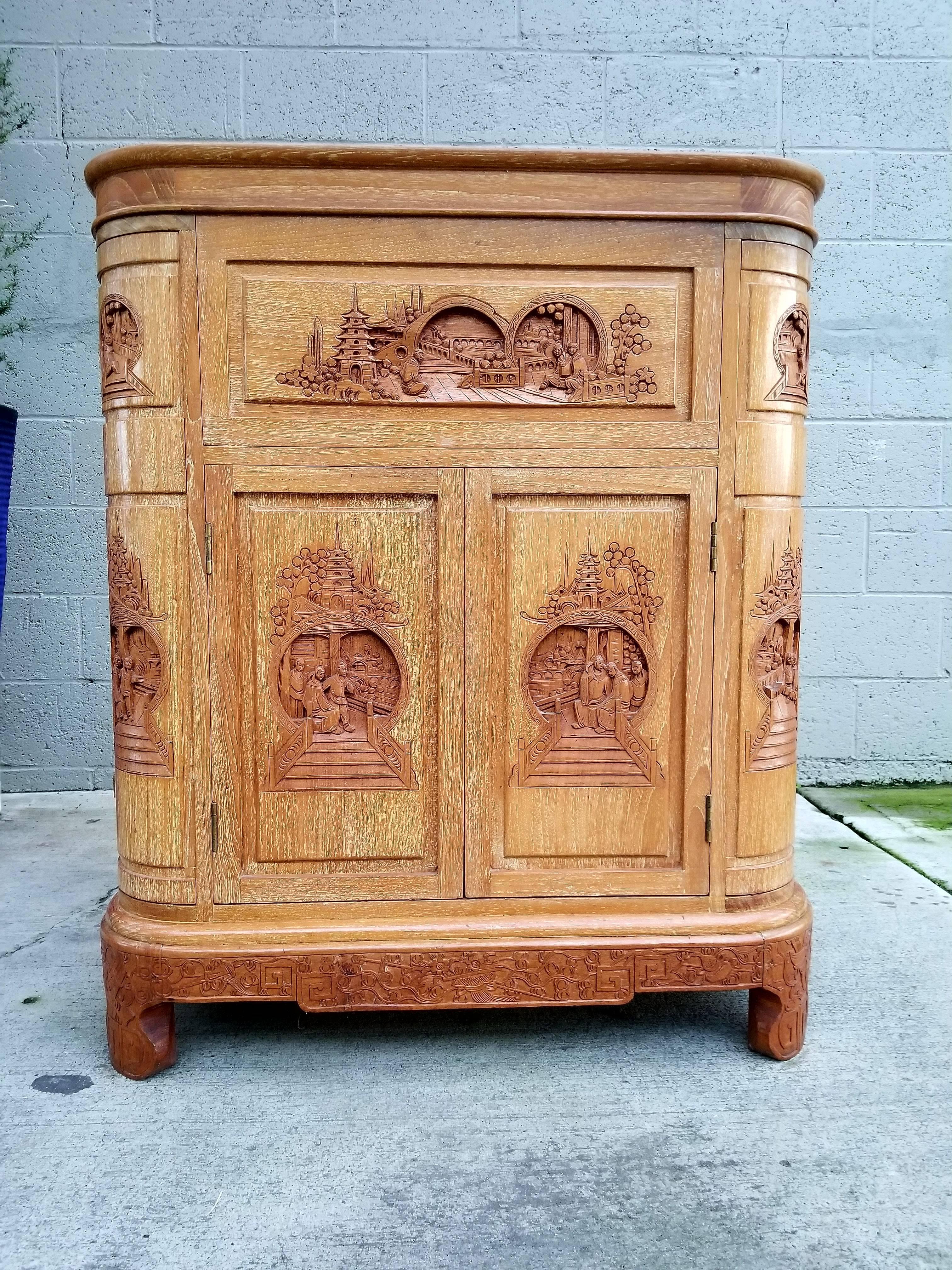 Superior quality, craftsmanship and materials. Exceptional original condition. Carved hardwood compartmentalized flip-top dry bar by George Zee & Company, Hong Kong, circa 1960. Depicting architectural structure with figures and trees. Original