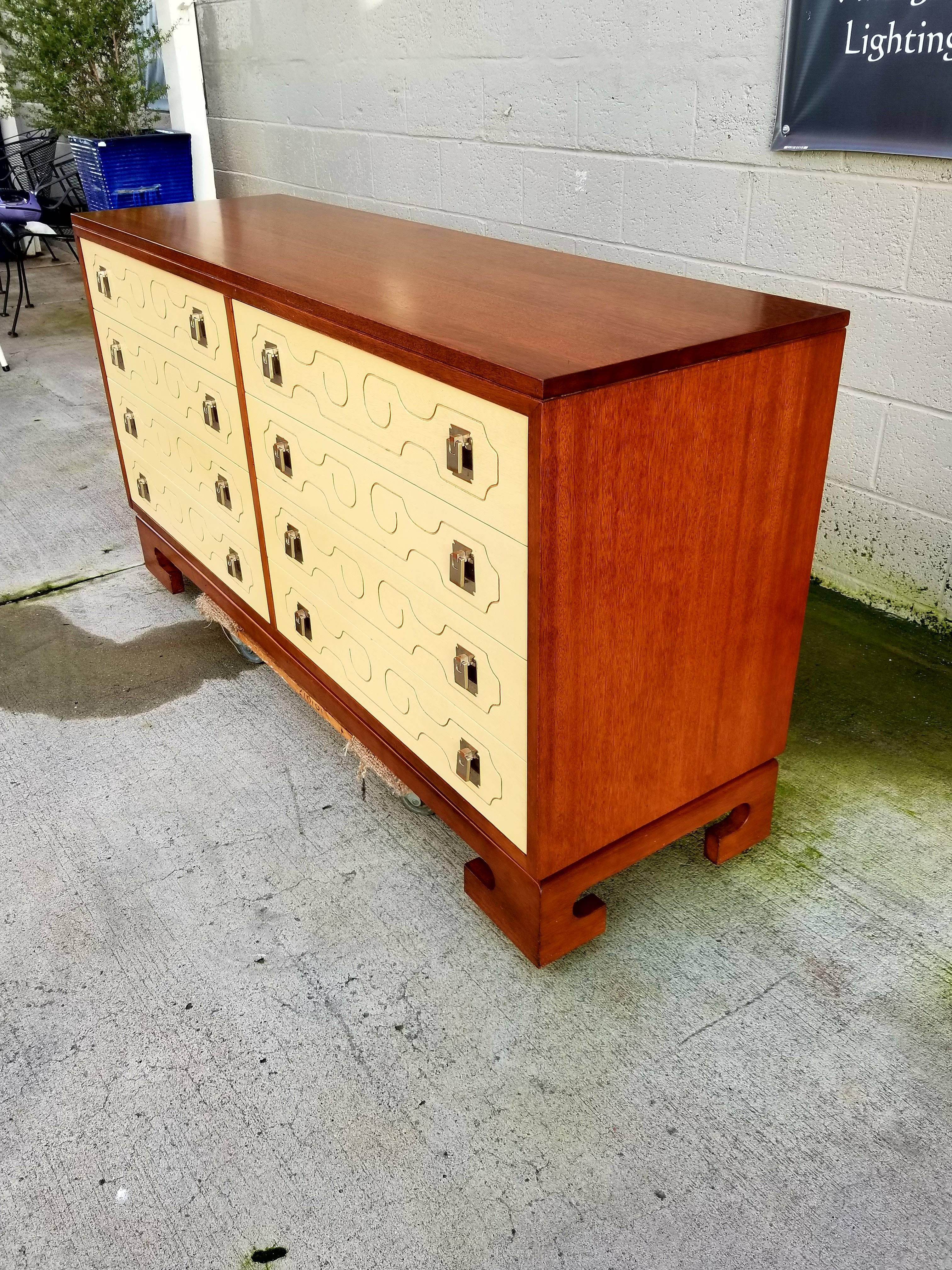 A lacquered eight-drawer dresser in the manner of Tommi Parzinger and/or Dorothy Draper. Exceptional craftsmanship and materials. Base, top and drawer fronts are solid mahogany. Secondary woods are also solid mahogany. Steel drawer glides offer