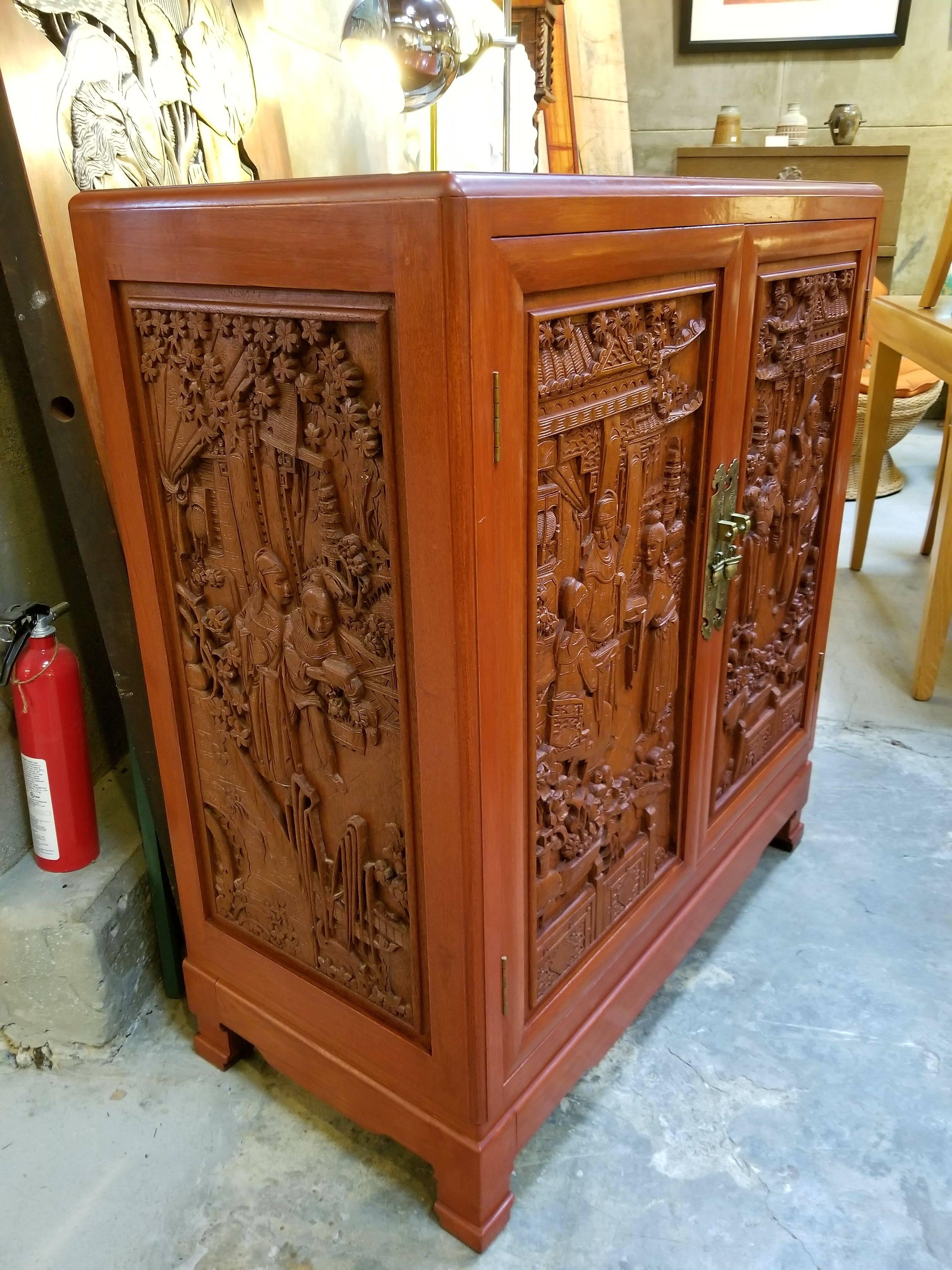 Carved hardwood fitted cabinet or dresser by George Zee Furniture Company, circa 1960s. Deep relief hand carving on three sides. Interior consists of 6 drawers. Excellent original condition and finish.