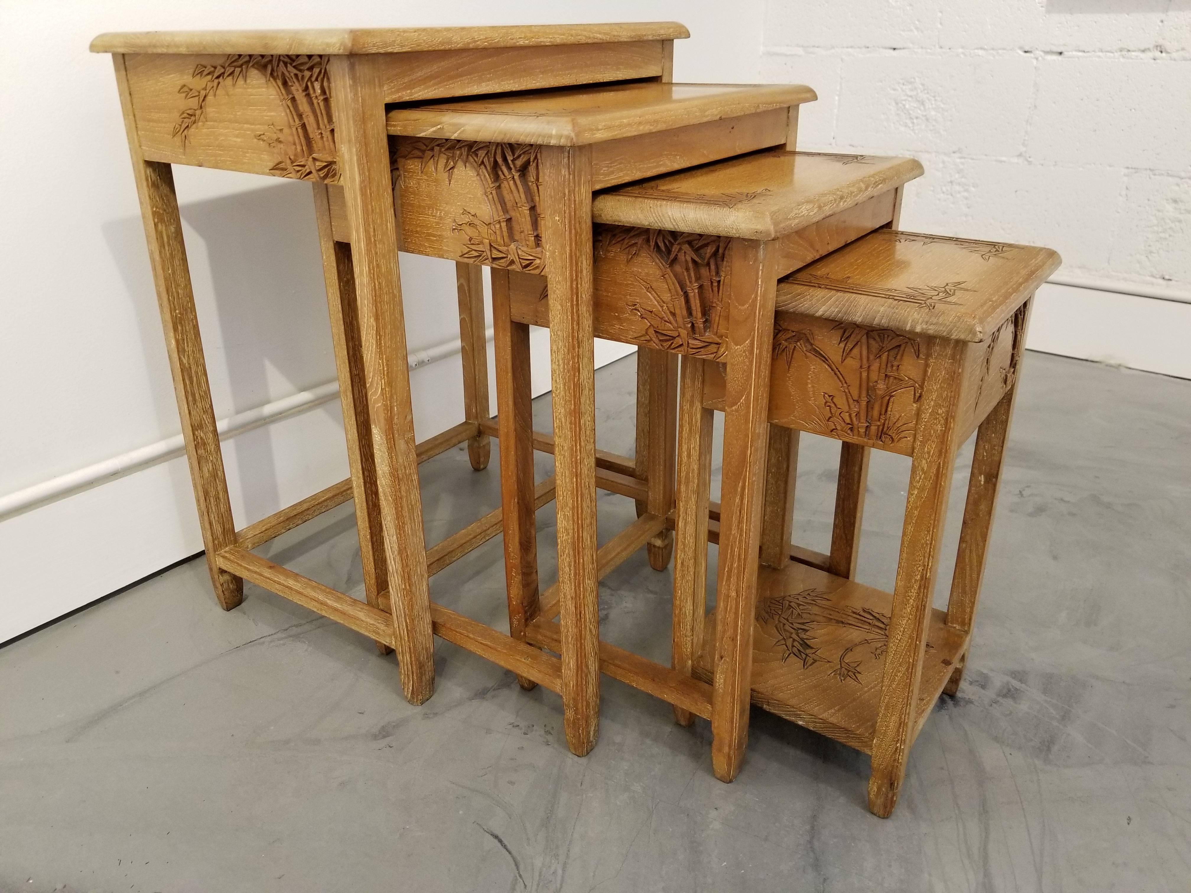 A set of four carved hardwood nesting tables by George Zee & Company. Hong Kong, circa. 1960. Deep relief hand carved 