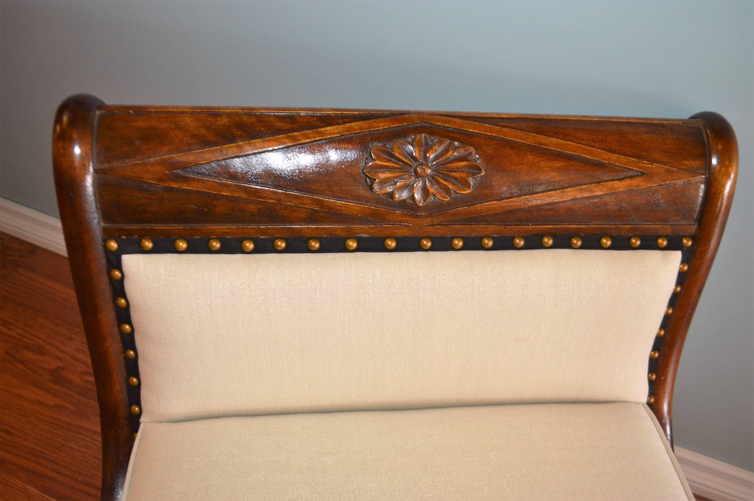 A very elegant Empire style chaise in solid mahogany with hand-carved swan motif at each end of the chaise. The gold velvet fabric has not been changes but has been dry cleaned.