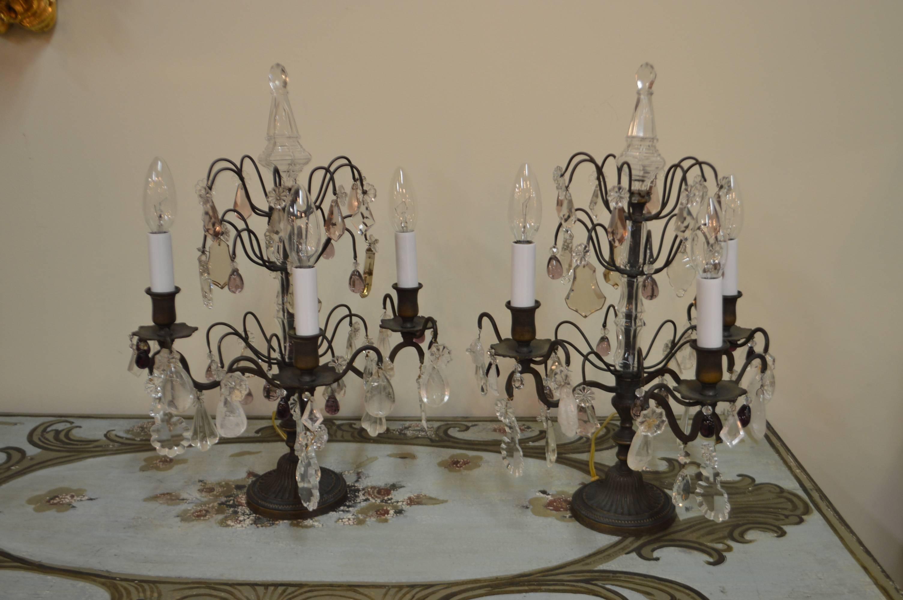 Pair of bronzed and crystal girandoles (candelabra) having three lights facing the front to facilitate placing them against a wall. They have been newly rewired with American standard approval.
The crystals vary in size and color, there are