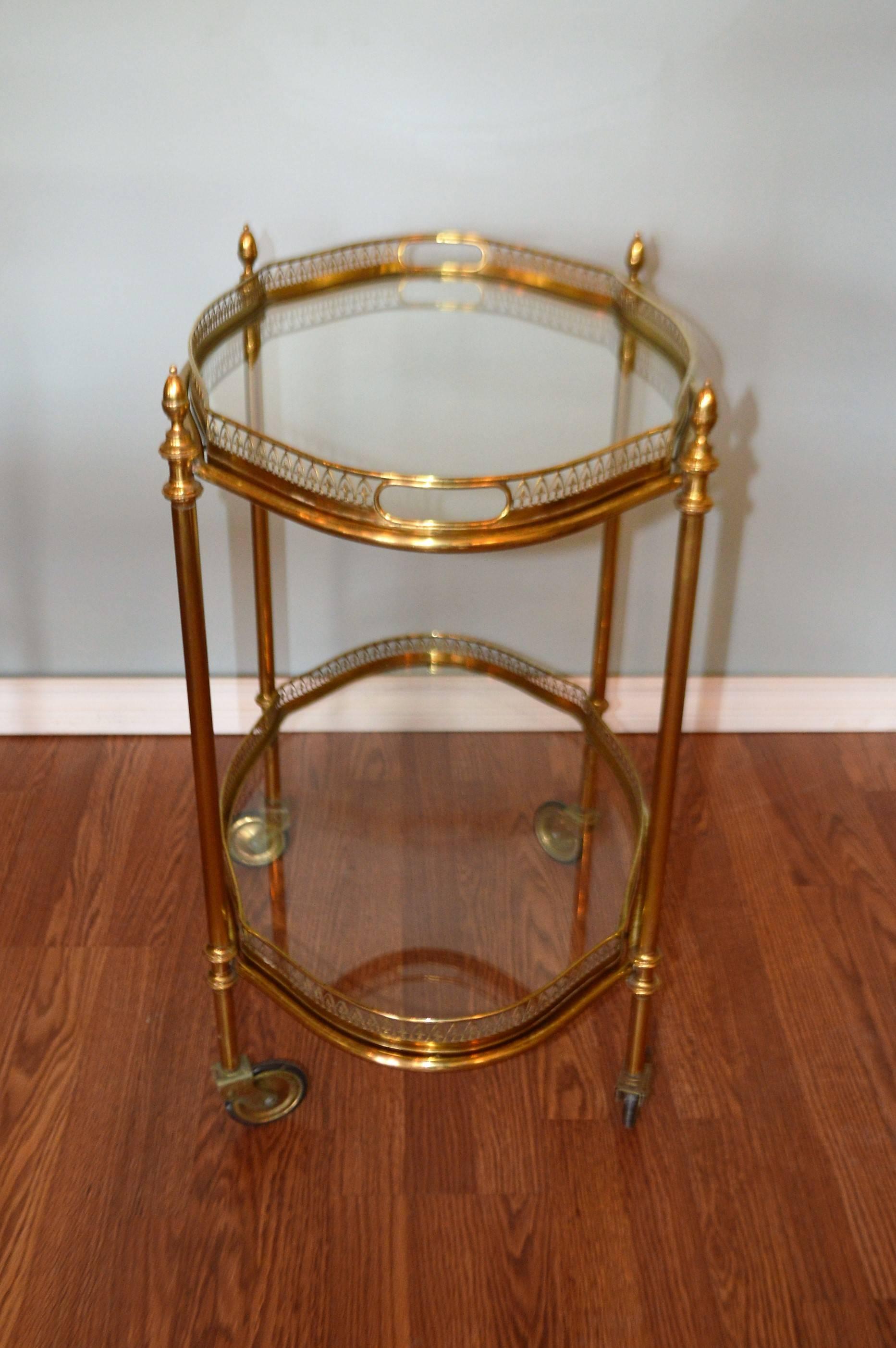 French Mid-Century brass bar cart with two removable trays. Gothic style pierced
galleries around both trays. Cart moves easily on caster wheels.