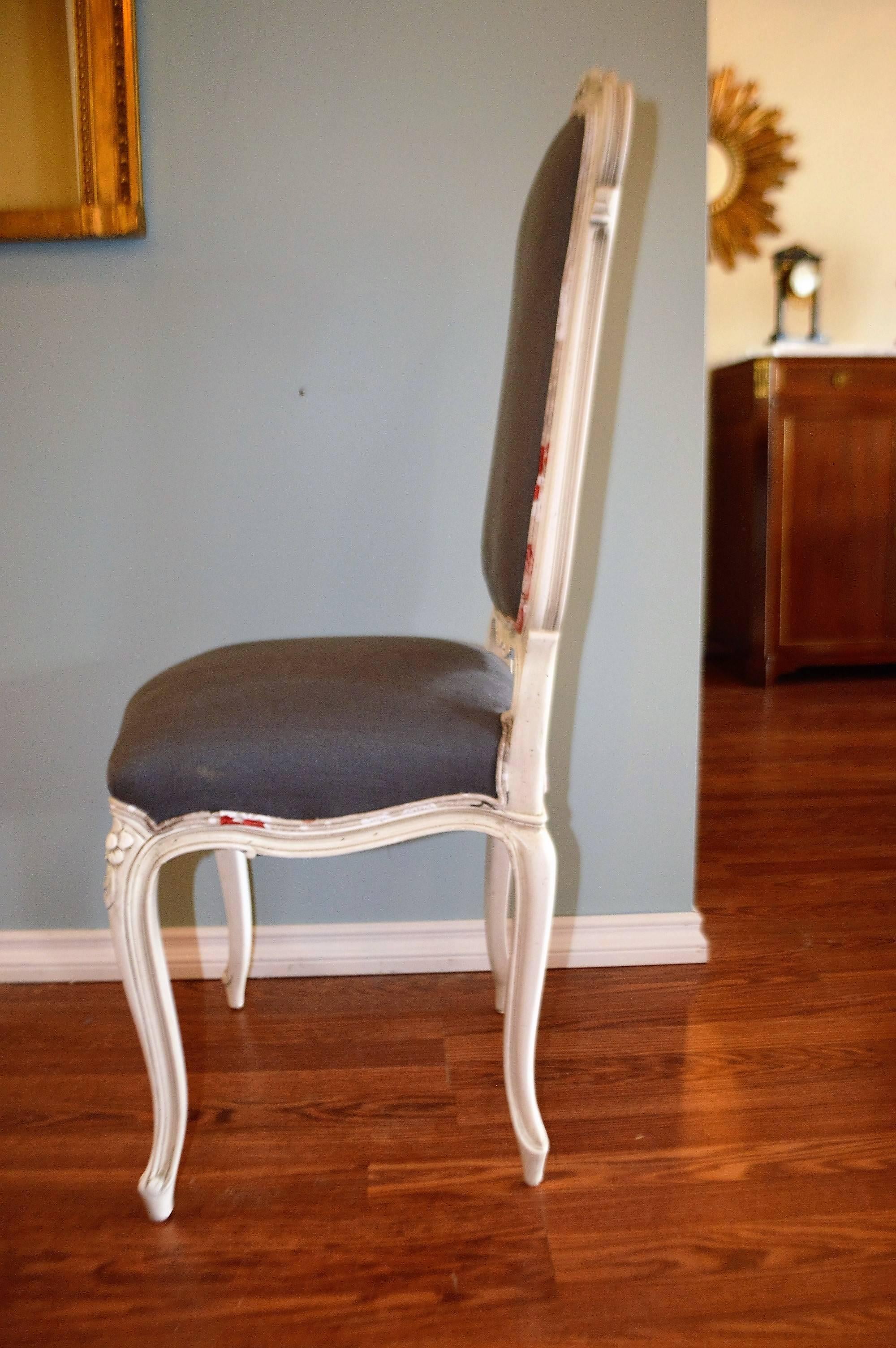 Set of eight high back, painted dining chairs with hand-carved design on the back and the apron frame. They have been newly upholstered with a charcoal linen for the front and with an attractive complimentary pattern fabric in linen for the back.