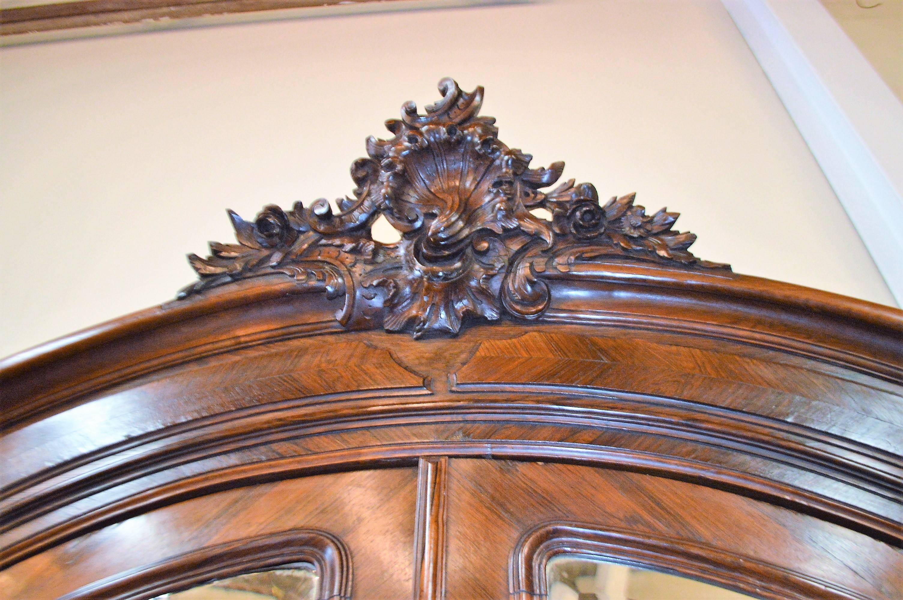 Beautiful and offering lots of storage in the Louis XV style armoire with amazing hand-carved details. The hardware and the mirrors on the doors are original and in good condition. The interior has five shelves that can be adjusted to your needs.