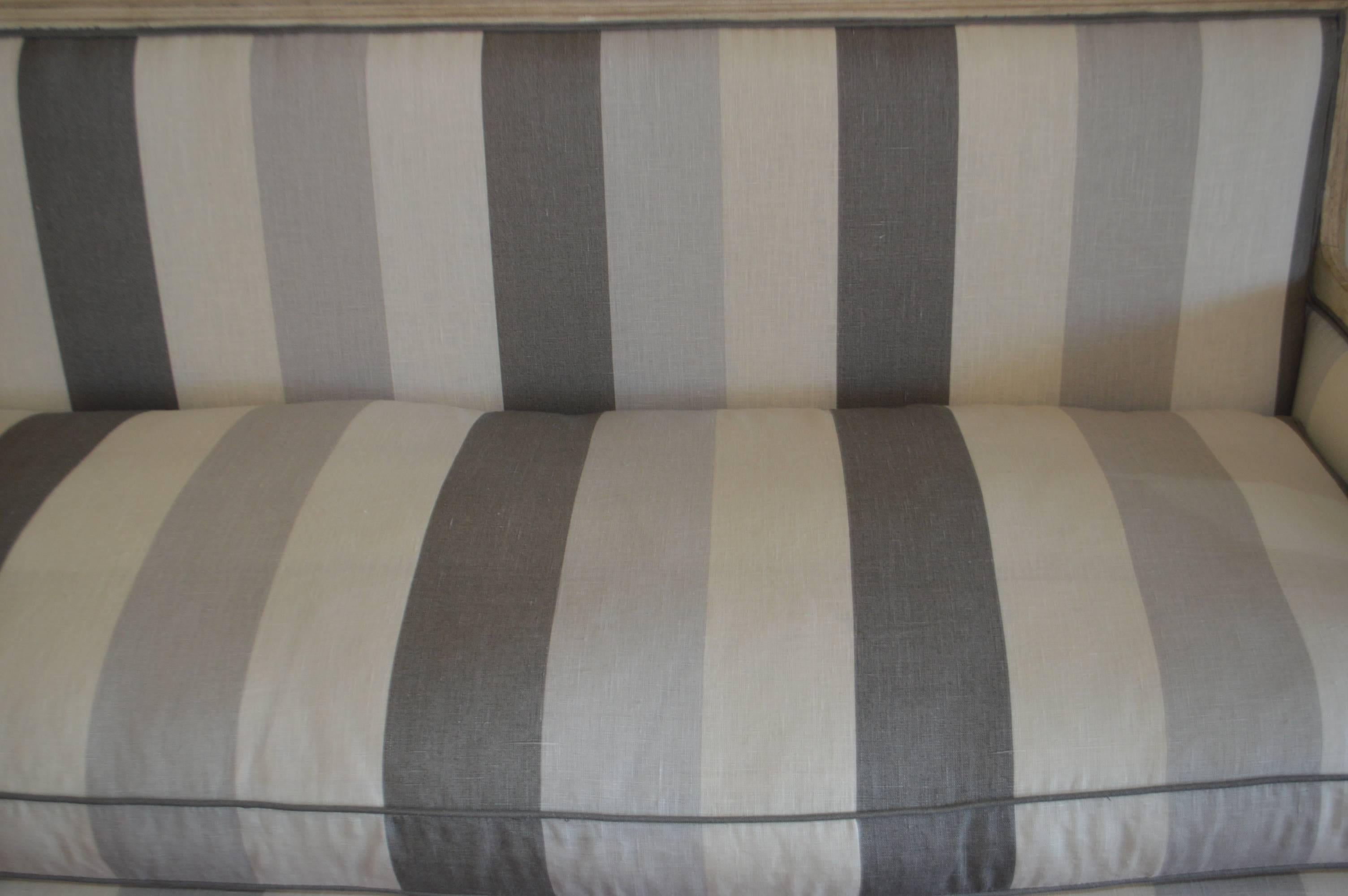 Louis XVI style square back sofa having the original patina but newly upholstered in a stylist and an attractive stripe linen fabric. The seat cushion is a mixture of dawn and feathers, very comfortable sofa.
The colors of the linen stripe are