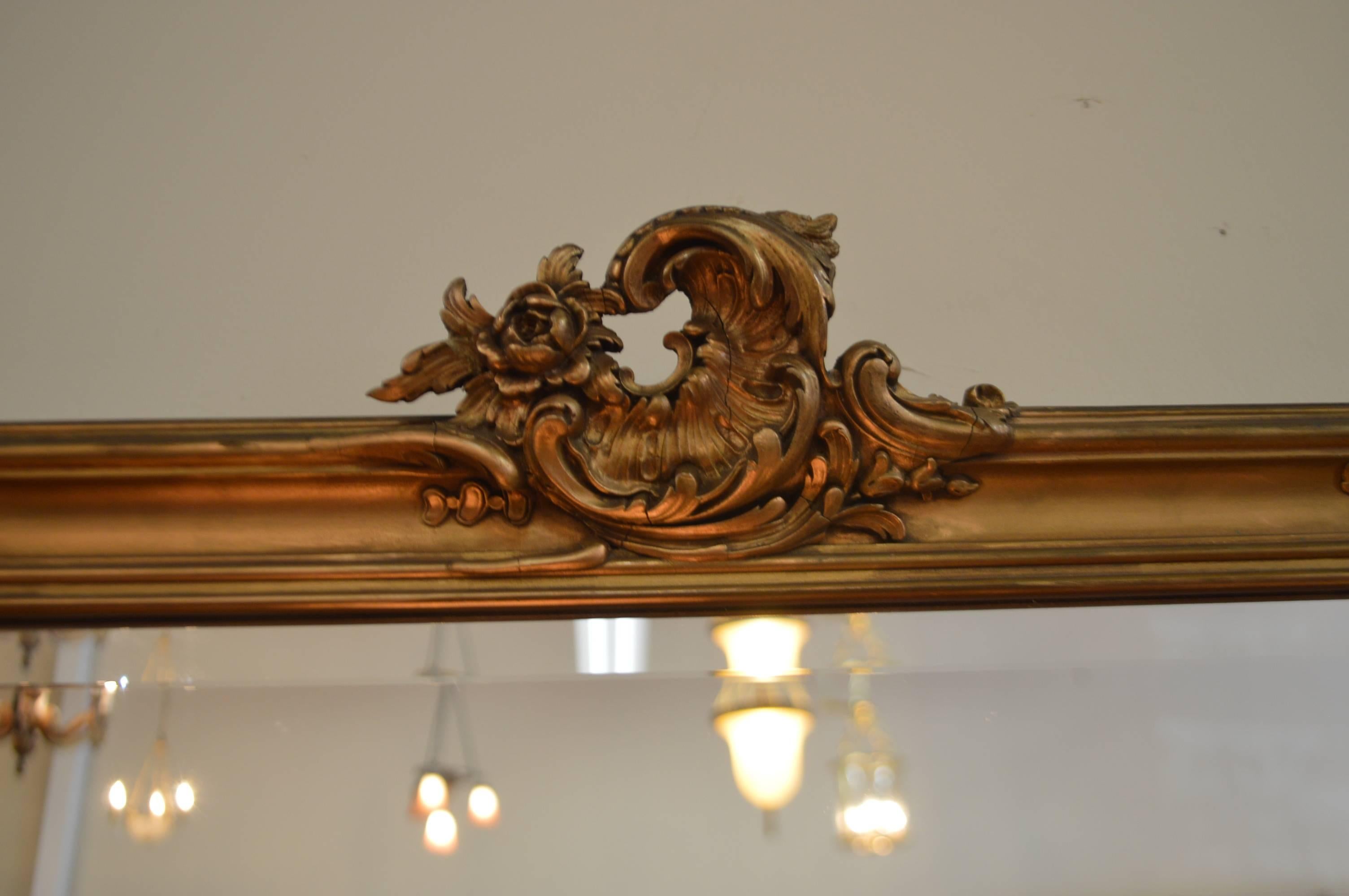 New beveled mirror was inserted in the hand-carved details Louis XV style gilded mirror. All repairs needed were done, there are no loose pieces on the carving elements of this mirror.