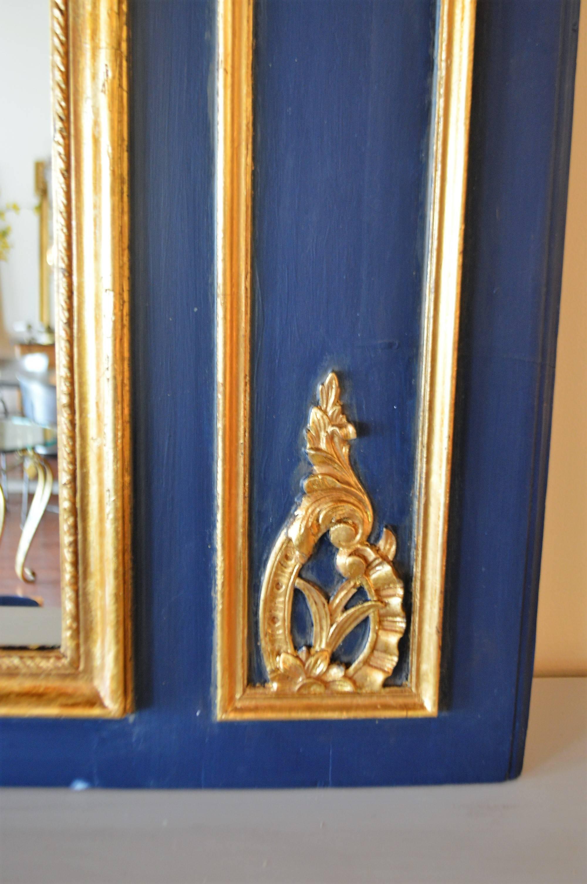 A stunning dark blue trumeau mirror with hand-carved gilded details accents.
Both mirrors are new.