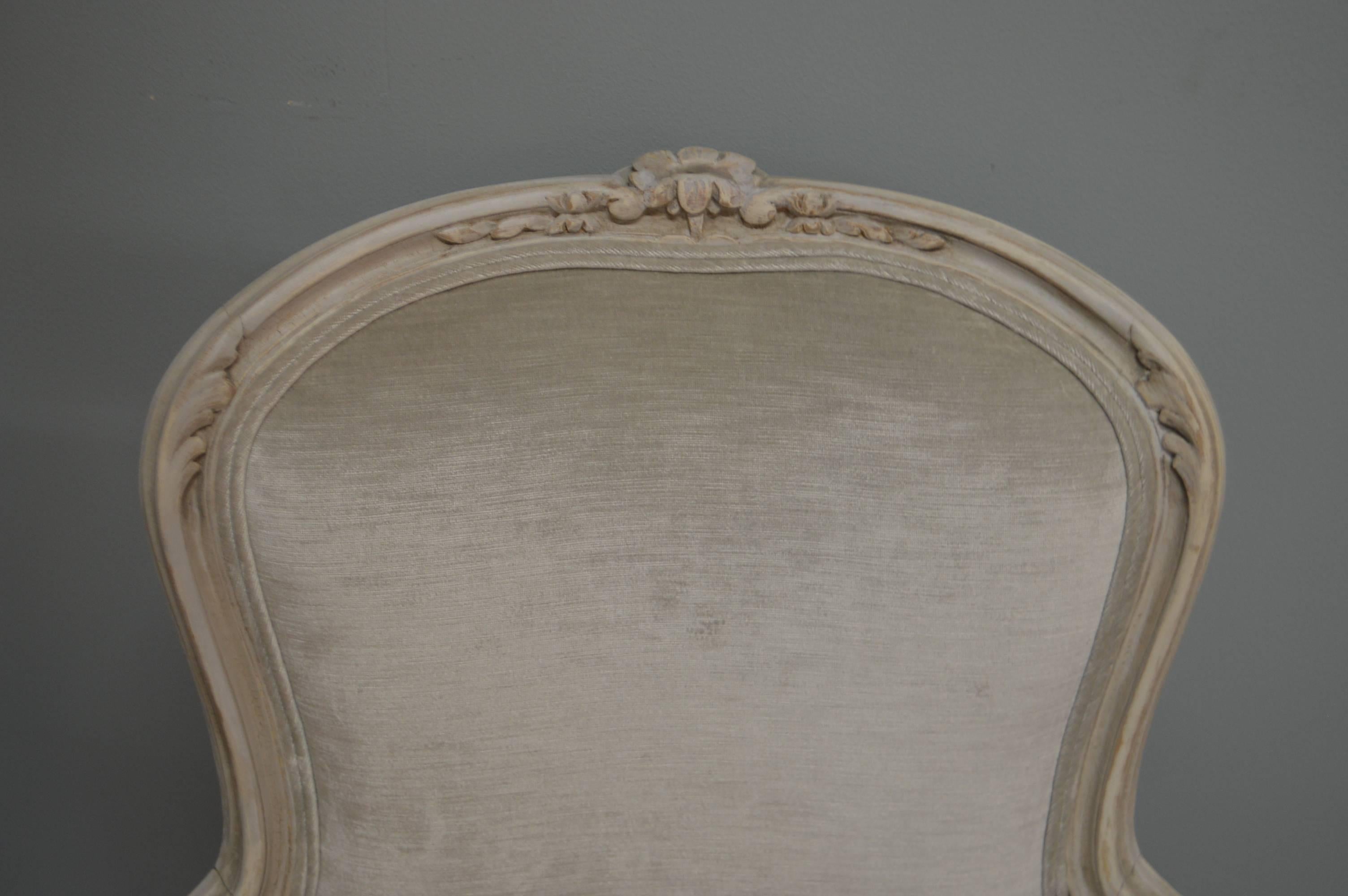 The Louis XV style painted frame of these bergere chairs is from France, circa 1920, with attractive floral hand-carved details.
The original frame has been slightly retouched to harmonize with the luxurious light grey velvet fabric.
The bergeres