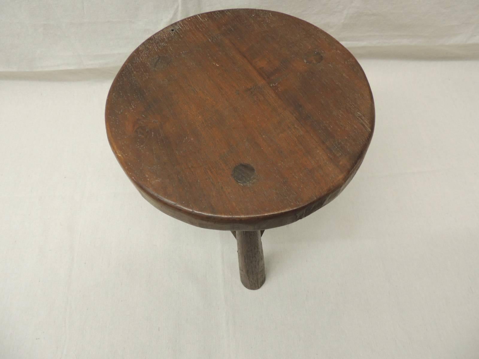 Round wood tripod three legged low stool. Great side table for slipper chairs, drinks table or telephone table. Original manufacture brass plate under the top.