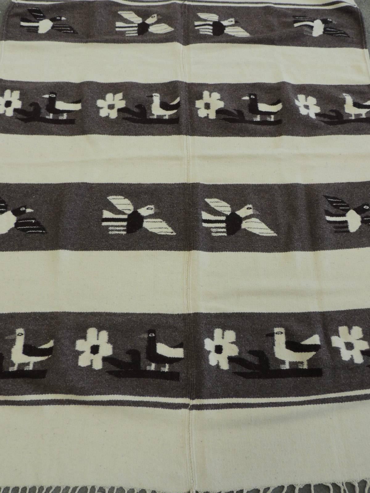 Large vintage alpaca throw or saddle blanket in a Navajo style design, depicting birds and flowers. Natural and brown stripe pattern, with hand-knotted long fringes.