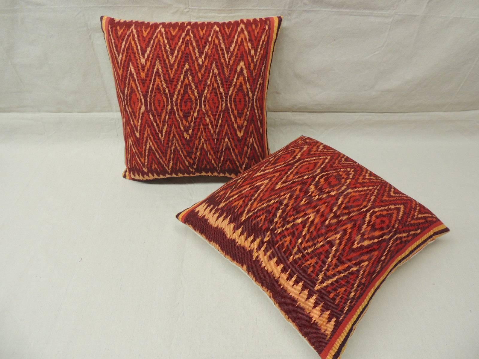 Pair of vintage Ikat pillows. Woven (not printed.) tribal pattern in shades of yellow, red, brown, orange and with natural linen backing (flame stitch.)

   