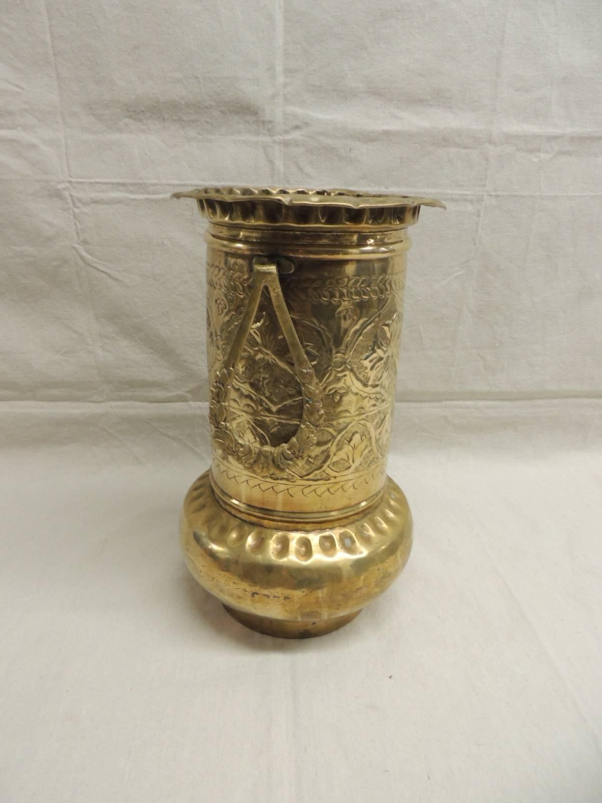 Tall handcrafted hammered brass Persian vessel in a floral design with pear shaped handles on either side. Finished on all sides.
Measures: 10” D x 15 “ H. 
 