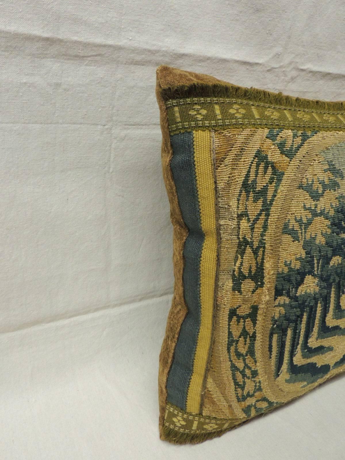 The antique tapestry depicts trees and the entry-way to a castle. In shades of: green, deep blue and gold. Tapestry is framed with an antique trim with golden chenille in the frame and backing.  Pillow hand-made and designed in the USA.  Closure by