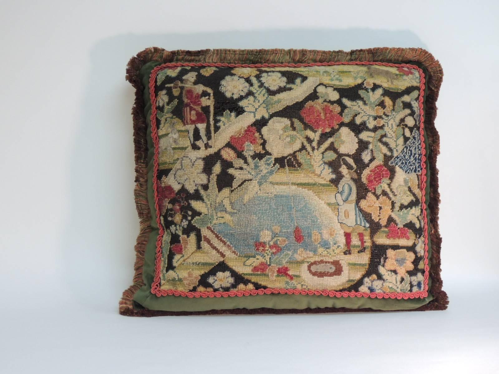 18th century French tapestry pillow.
18th century Gobelin tapestry pillow depicting a fishing scene in a forest; floral and animal pattern in shades of green, red, blue, gold and orange. Framed with hunter green silk velvet accentuated with a red