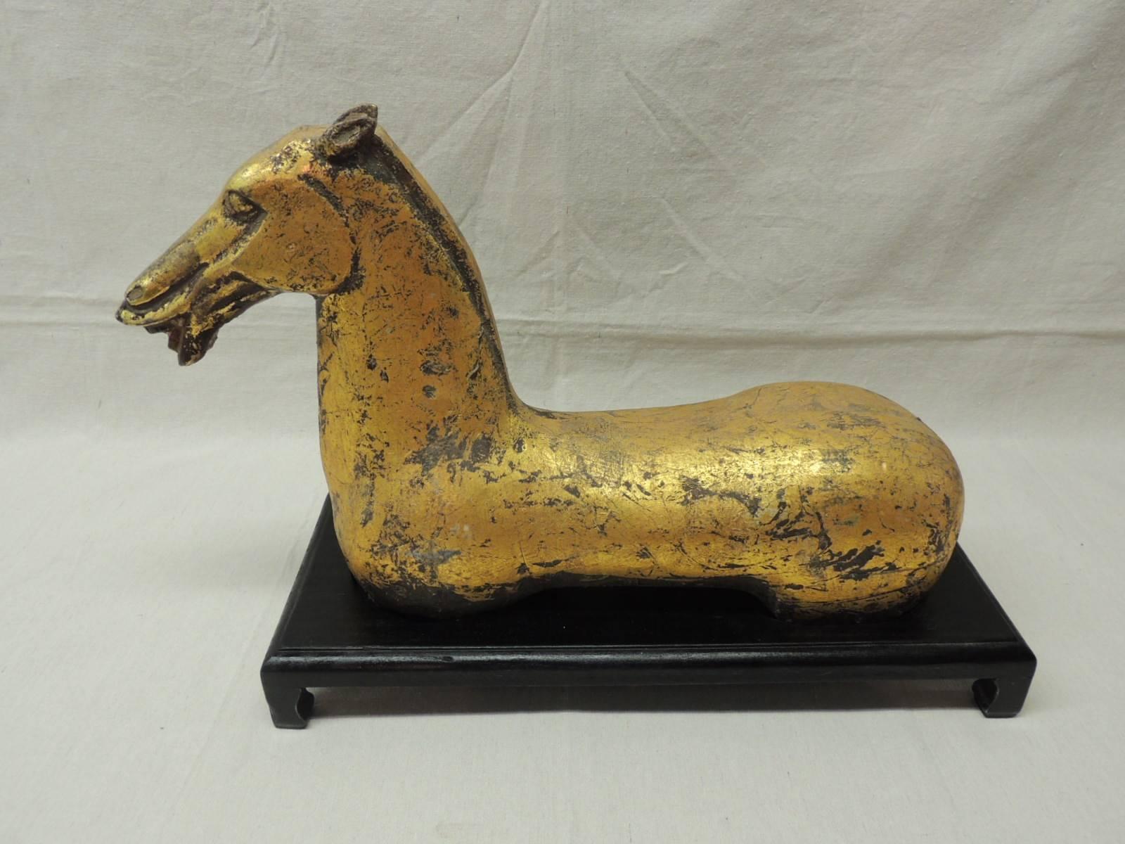 Ancient Han dynasty style gilded terracotta horse on wood stand. The Chinese horse bust is hollow inside (very heavy) The ebonized wood Stand has a high gloss finished. This piece is a majestic sample of equine sculpture.
