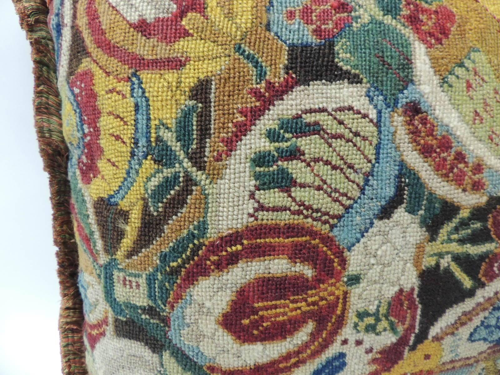 French needlework tapestry decorative multi-color pillow hand-stitched with an 18th century fragment that depicts a floral pattern. The color palette in the front panel depicts shades of mustard, yellow, green, orange, glue and garnet red. To