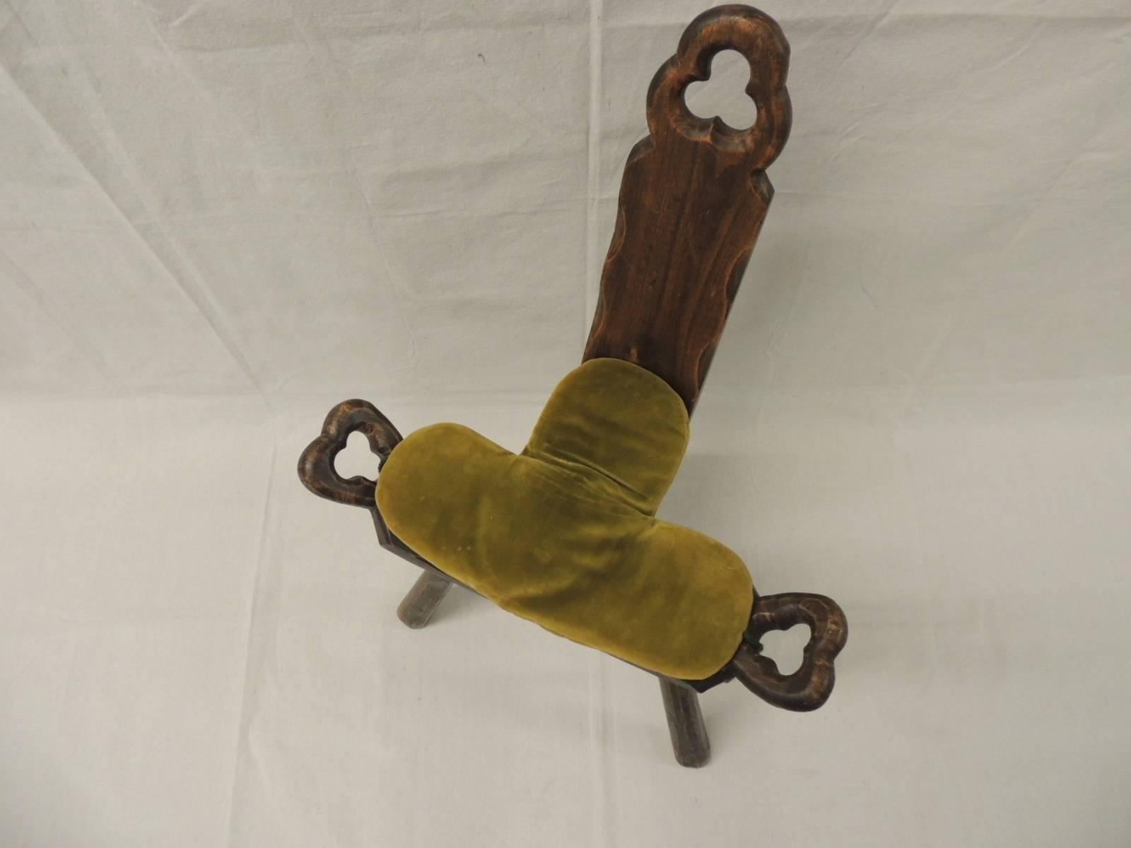 Vintage Primitive African birthing chair with antique green velvet cushion with tassels. Quatrefoil details on each side: “an ornamental design of four lobes or leaves as used in architectural tracery, resembling a flower or four-leaf clover.”
