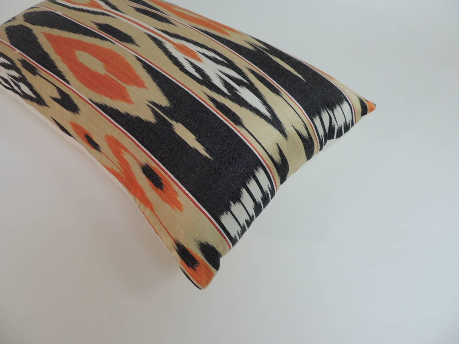Offered by the Antique Textiles Galleries:

Pair of vintage silk Ikat bolsters decorative pillows. Hand-crafted with a textile from India, 1960s: an Ikat striped pattern textile in shades of black, gold, orange and white with natural linen backings.
