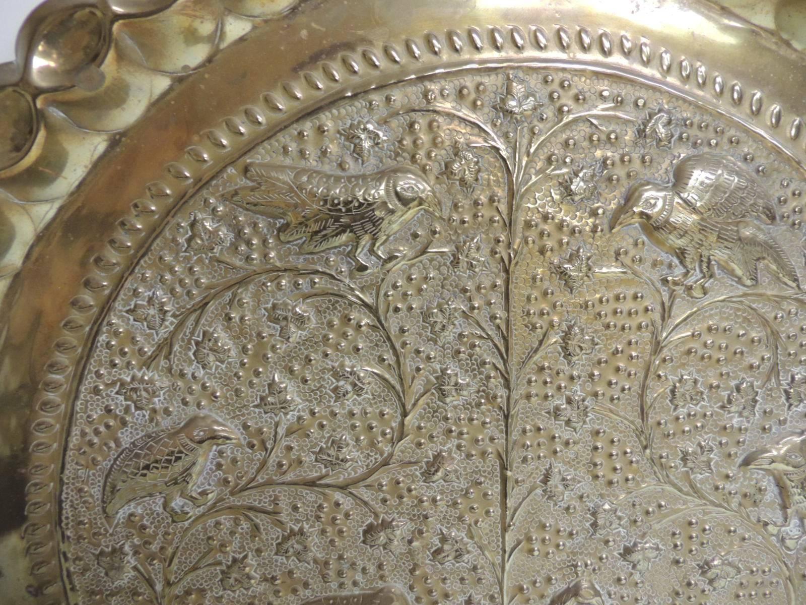 Vintage Persian brass round tray depicting the tree of life and birds. The repousse style tray with pinched edging all around top. Small hanging hook in the back.
Size: 19