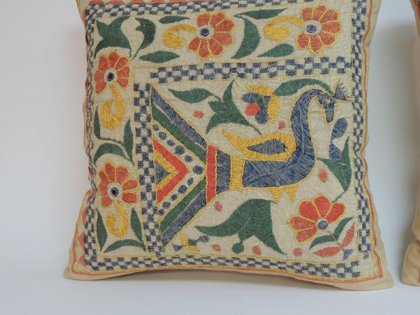 Pair of colorful Indian hand embroidered decorative pillows. Front panel textile was embroidered with cotton threads on linen and has been reinforced to add strength to the pillows. Decorative pillows depict peacock and is framed with yellow