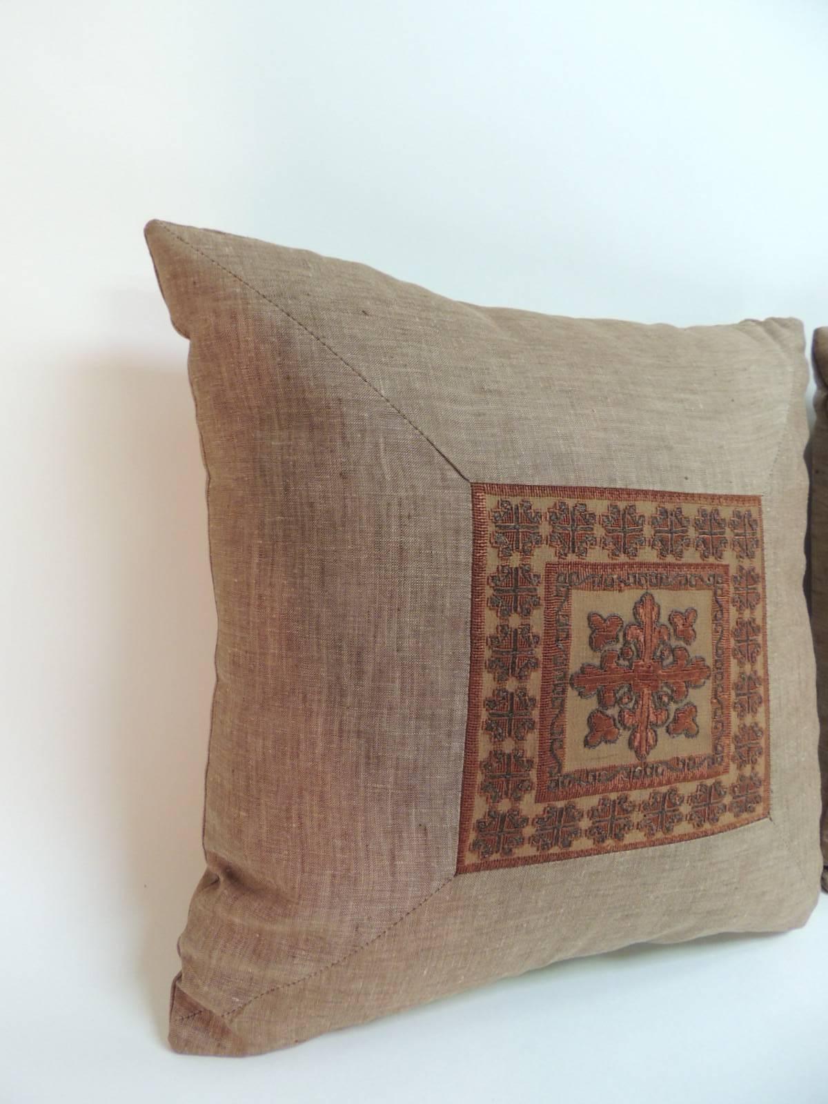Pair of 19th century Persian decorative pillows with silk threads embroidered on sheer tulle and framed with textured brown vintage linen same as backing. The center embroidered square, (6.5” by 6.5” measurement) depicts a stylized fleur de lis