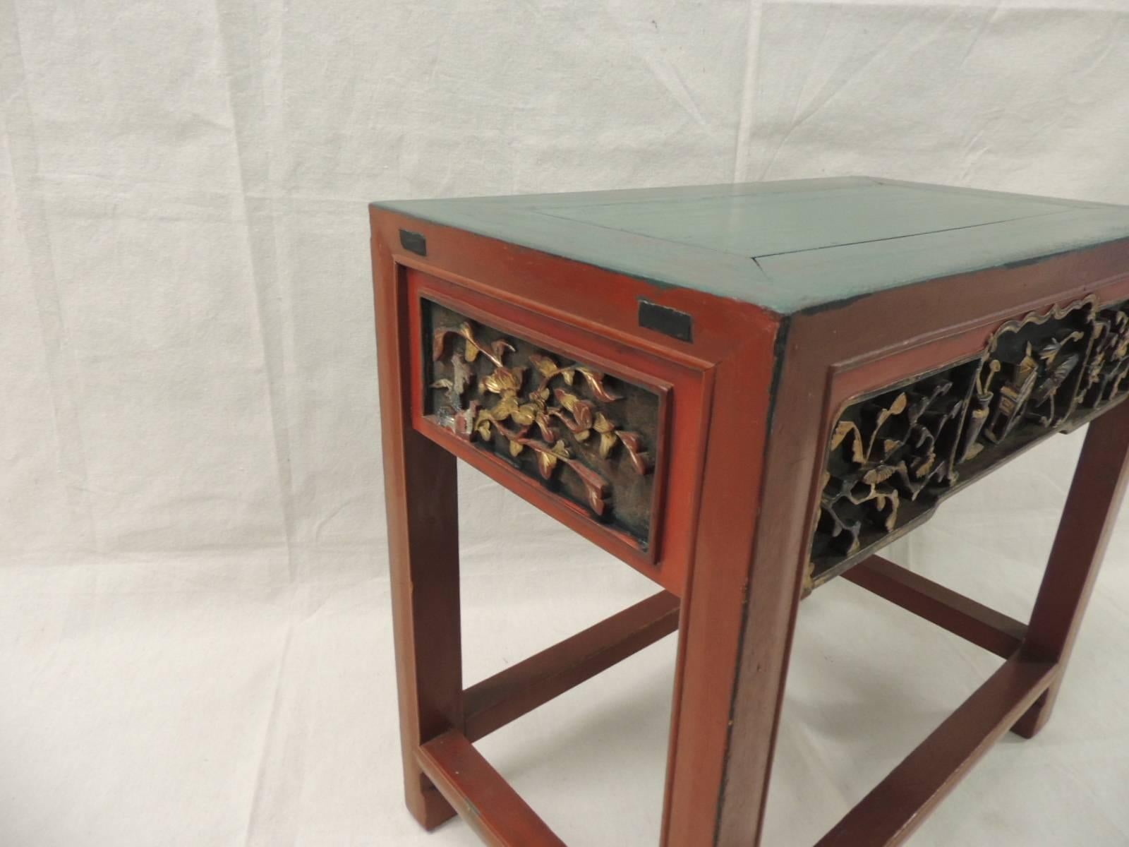 Offered by the Antique Textiles Galleries:
Red wood Chinese lacquered side table. Red lacquer and gold accents with a jade green painted top. 
Carving on top front, back and all around.
Size: 11 x 19.5 x 18.