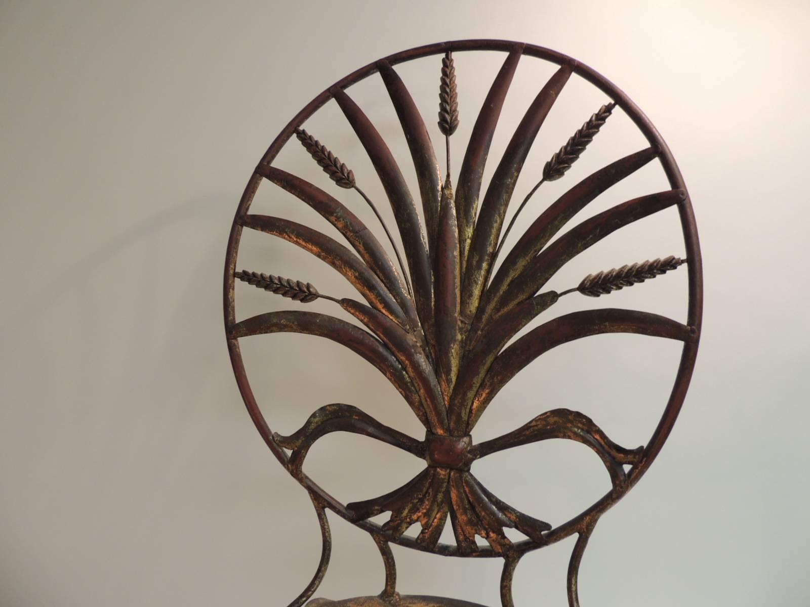 Hollywood Regency style Italian gilt metal wheat sheaf chair.
Single metal bistro chair with gilded metal finish in the Hollywood Regency style. The back of this vintage single chair is an oval containing a fanned out sheaf of wheat design.