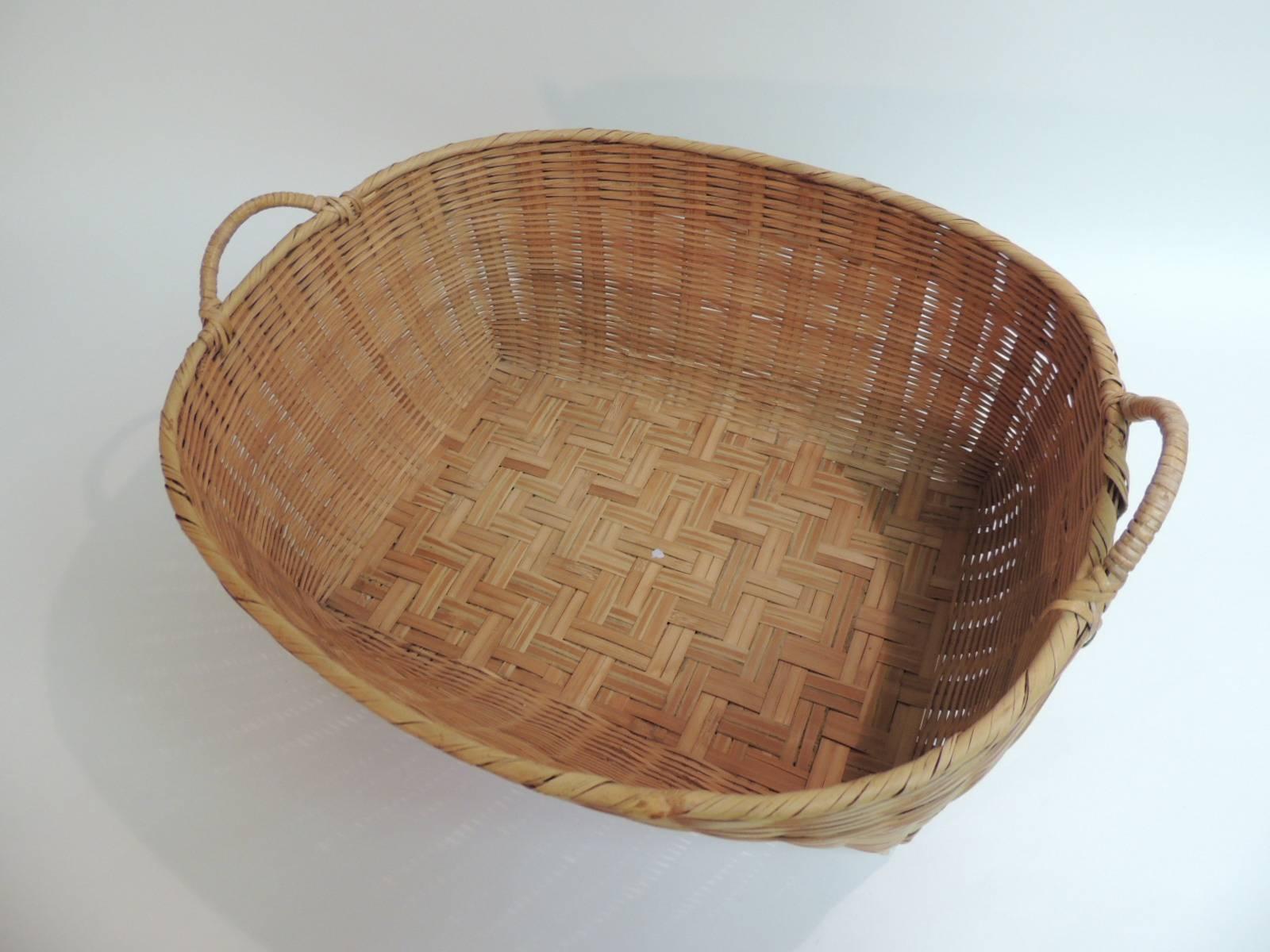 American country oval large wicker woven basket. 
American country woven wicker oval basket. Decorative basket with handles. Large basket with flat wood bottom underside supports. Ideal for magazines as a magazine stand, under a cabinet, for