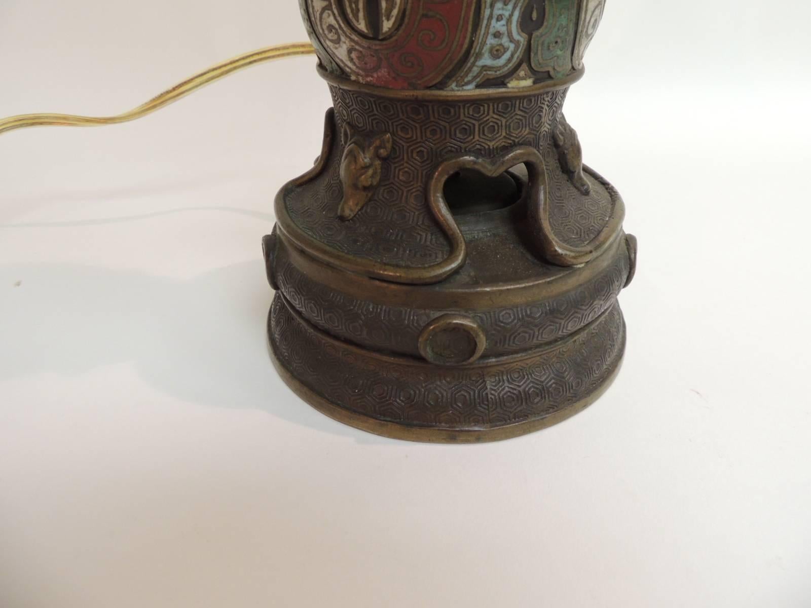 Antique bronze and Cloisonne Asian table lamp.
Antique bronze and cloisonne Asian table lamp with intricate patterns and designs. Asian antique table lamp depicting lions and dogs faces in the stylized traditional Japanese fashion. No shade or harp.
