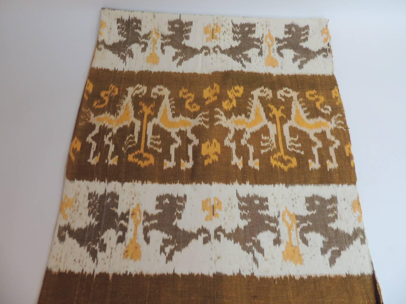 Offered by the Antique Textiles Galleries:
Vintage woven yellow and natural Ikat textile panel with fringes
Large Ikat textile panel/throw with fringes on both ends. Depicting tribal anthropomorphic figures of lions and horses. Decorated with warp