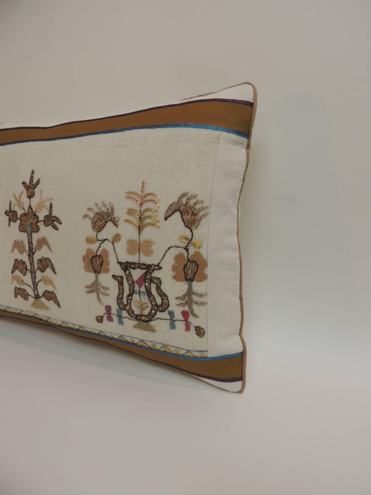 Antique hand-embroidery floral decorative pillow, silk and metallic threads embroidered onto sheer linen. Antique embroidered textile pillow embellished with tan cotton frame featuring small silk trims at seams and tan rope cord all around. In