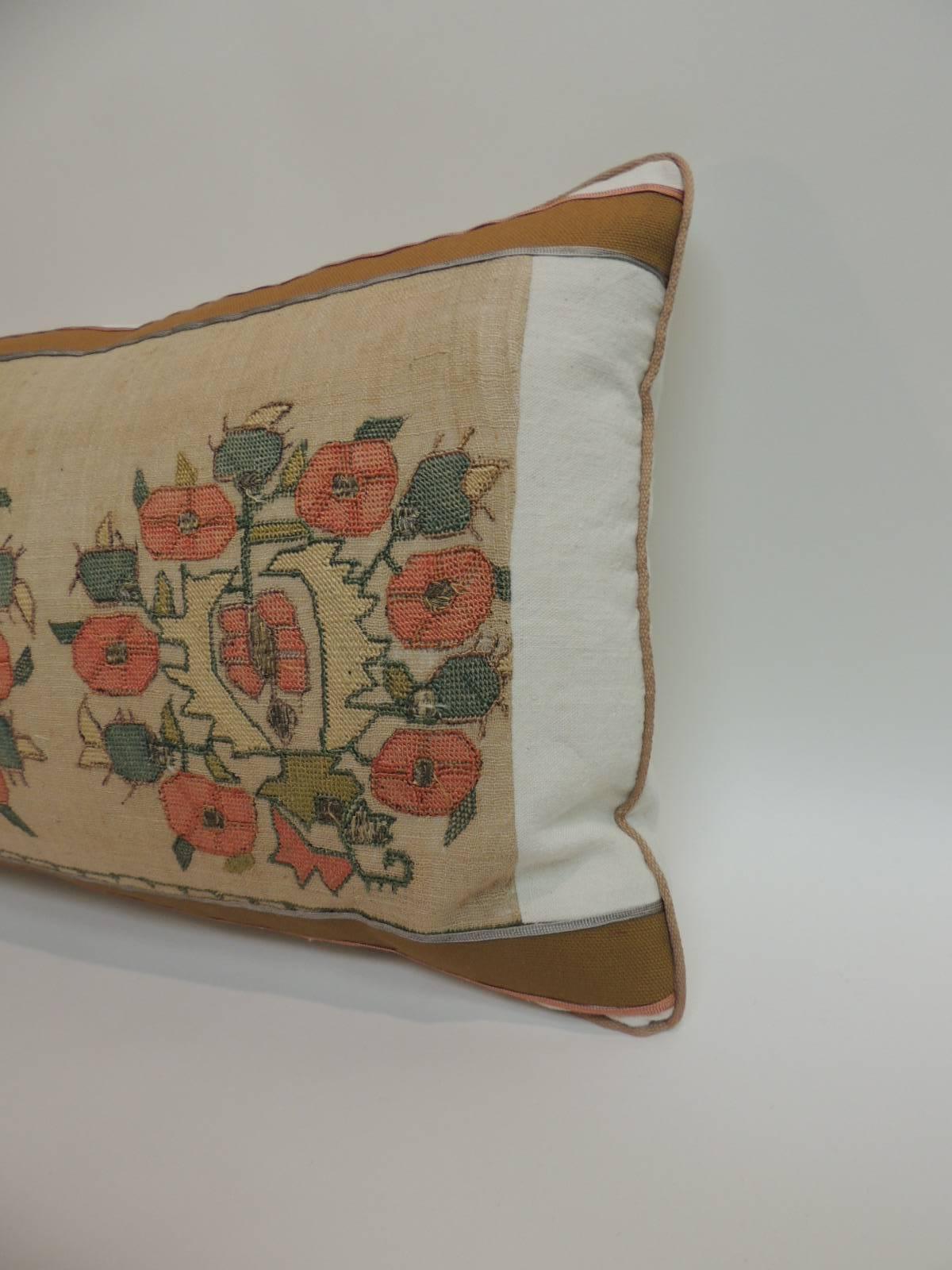 Antique hand-embroidery floral textile decorative pillow with silk and metallic threads embroidered onto sheer linen. Antique textile bolster pillow embellished with a tan cotton frame, featuring small silk trims at the seams and tan rope cord all