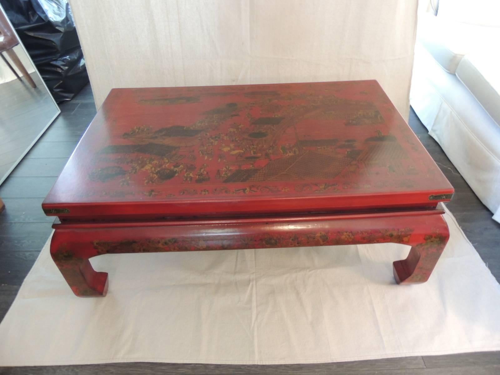 Offered by the Antique Textiles Galleries:
Monumental Chinese Cinnabar lacquer coffee table depicting a large court scene on the top. Details of flowers on legs and antique brass adornments on table corners. The red color is more ox blood in