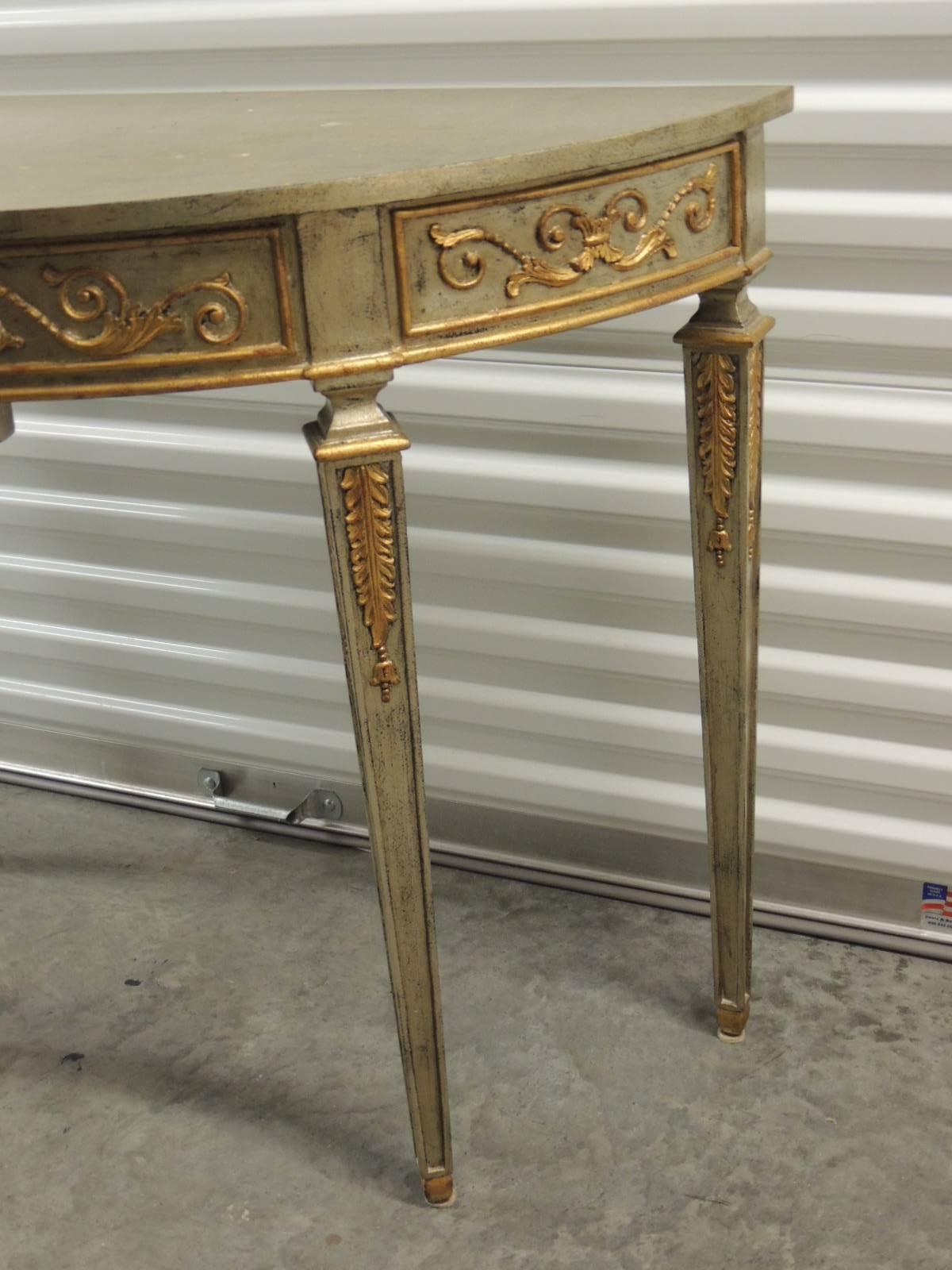 Antique Textiles Galleries:
Maitland-Smith demilune silver leaf and gold accents console table and fluted legs. Scrolling vines, rosette and acanthus leaves’ details all around. Original manufacture brass plaque on the back.
Ideal for an entry hall,