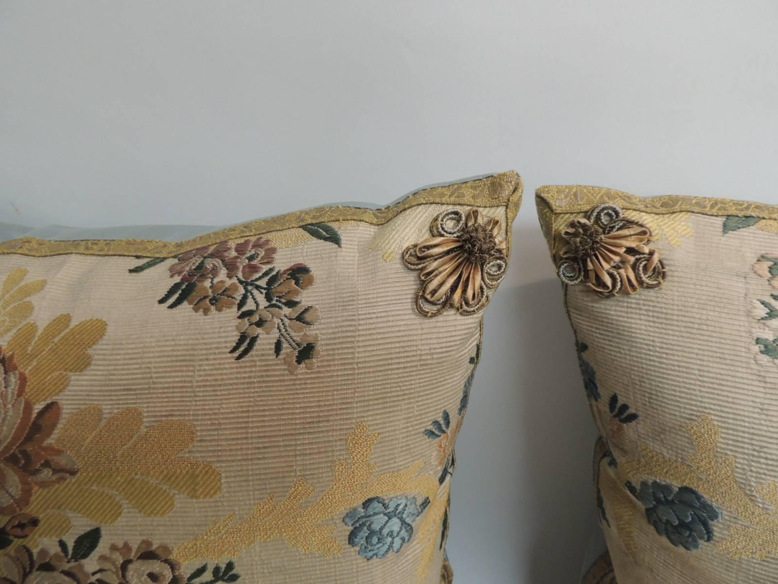 Pair of 19th century French silk Brocade in yellow and blue antique textile decorative pillows.
Embellished with gold metallic rosettes on each of the four corners and finished with soft blue silk backings. Antique textile decorative pillows