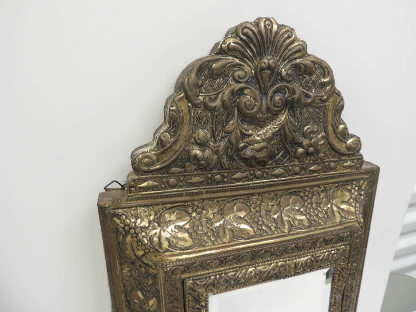 Offered by the Antique Textiles Galleries:
Antique embossed brass vanity reliquary with mirrored door and coat brushes.
Antique repose vanity reliquary in brass relief with mirrored door encasing a set of two coat brushes. Brass on wood and the
